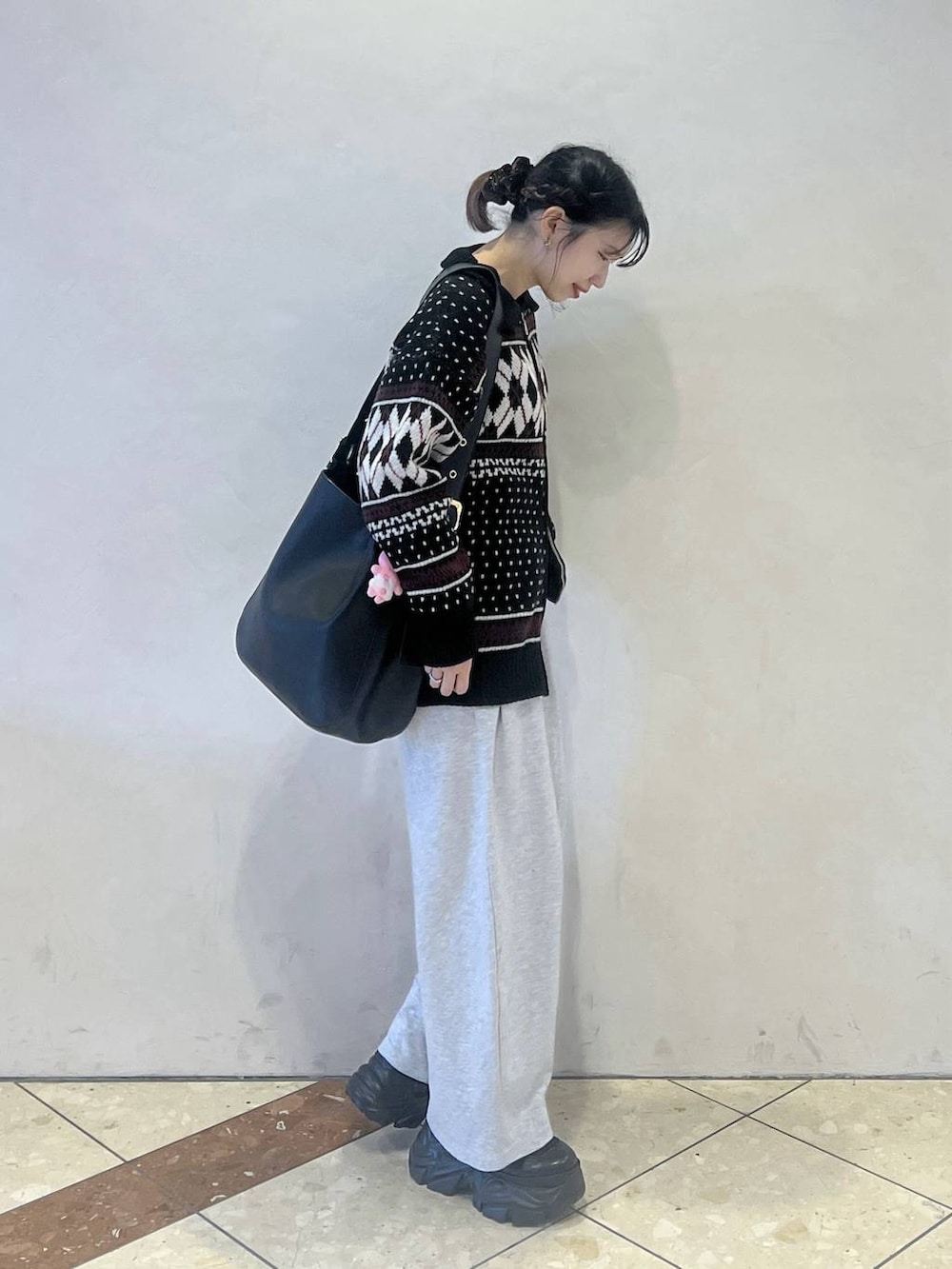 ブラック系のブーツ、ブラック系のショルダーバッグ、グレー系のスウェットパンツを着用したレディースの冬コーディネートの3枚目の写真