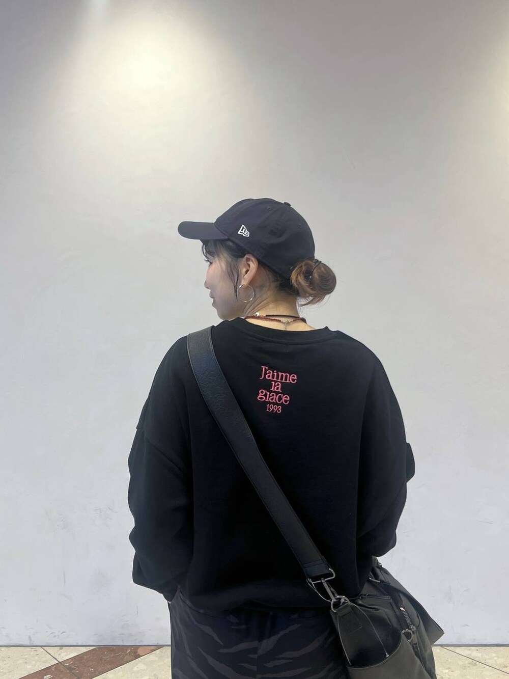 ブラック系のボストンバッグ、ブラック系のスニーカー、その他のスラックスを着用したレディースの冬コーディネートの2枚目の写真