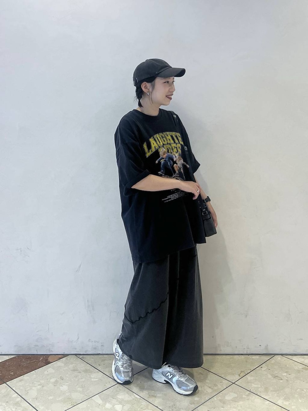 ブラック系のワンピース、ブラック系のショルダーバッグ、ブルー系のTシャツ/カットソーを着用したレディースの夏コーディネートの2枚目の写真