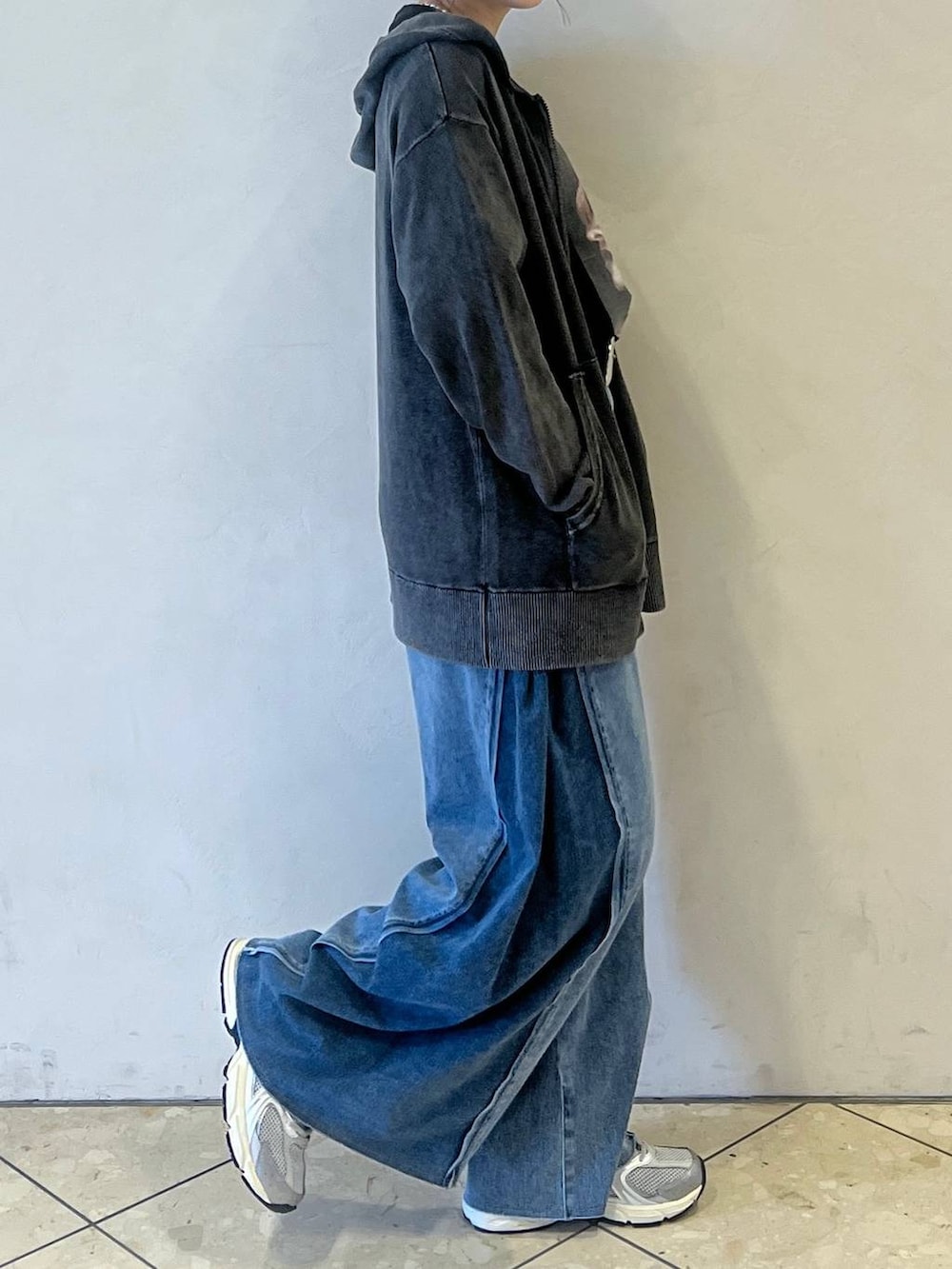 ブルー系のデニムパンツ、ブラック系のTシャツ/カットソー、グレー系のパーカーを着用したレディースの秋コーディネートの2枚目の写真