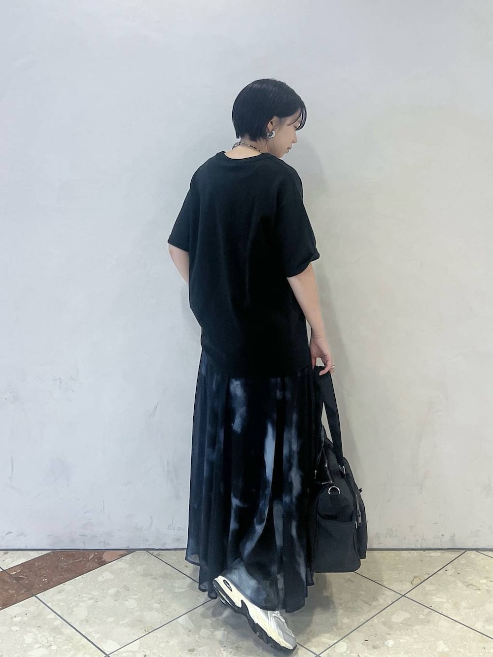 ブラック系のTシャツ/カットソー、ブラック系のスカート、ブラック系のボストンバッグを着用したレディースの夏コーディネートの2枚目の写真