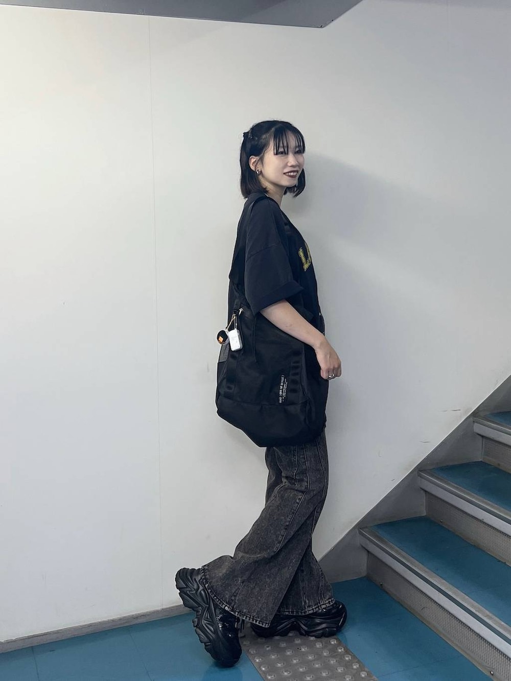 ブラック系のスニーカー、ブラック系のデニムパンツ、ブルー系のTシャツ/カットソーを着用したレディースの夏コーディネートの2枚目の写真