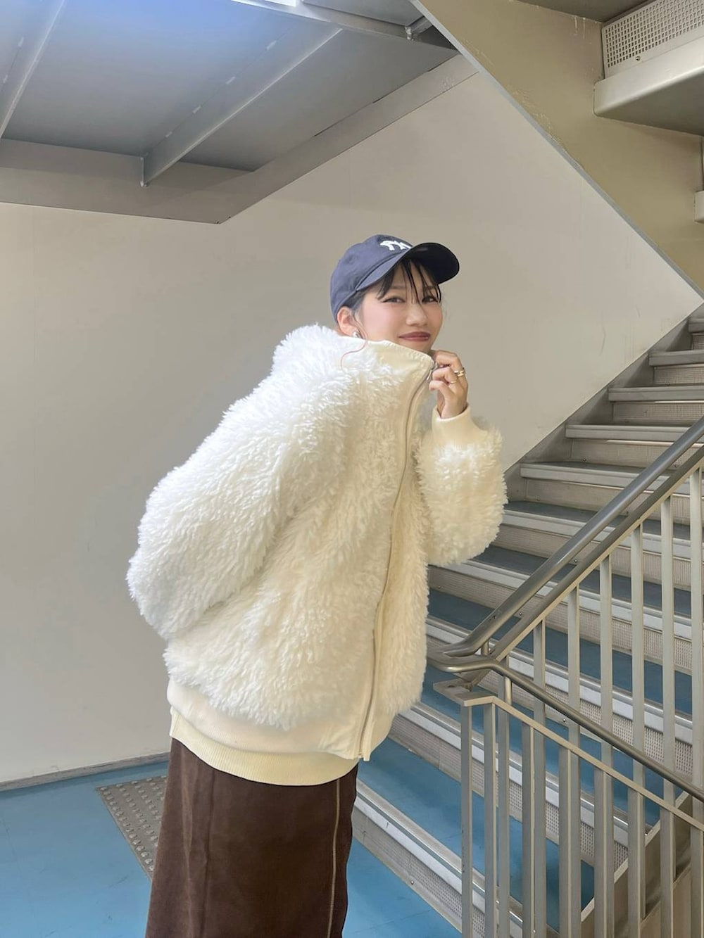 ブラック系のスニーカー、ホワイト系のブルゾン、ブラック系のボストンバッグを着用したレディースの秋コーディネートの5枚目の写真