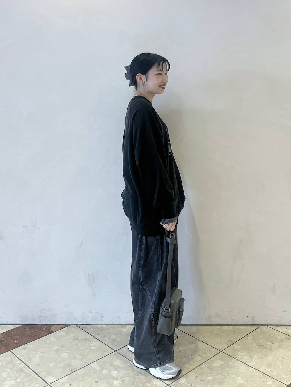 ブラック系のデニムパンツ、グレー系のTシャツ/カットソー、グレー系のショルダーバッグを着用したレディースの春コーディネートの3枚目の写真