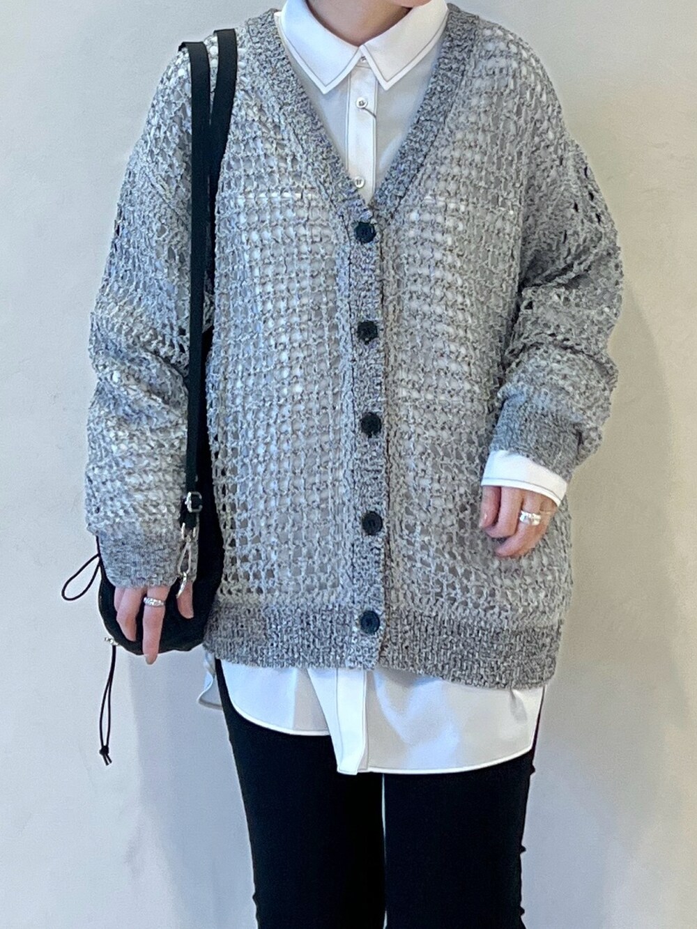 ブラック系のショルダーバッグ、グレー系のカーディガン/ボレロ、ブラック系のデニムパンツを着用したレディースの春コーディネートの3枚目の写真