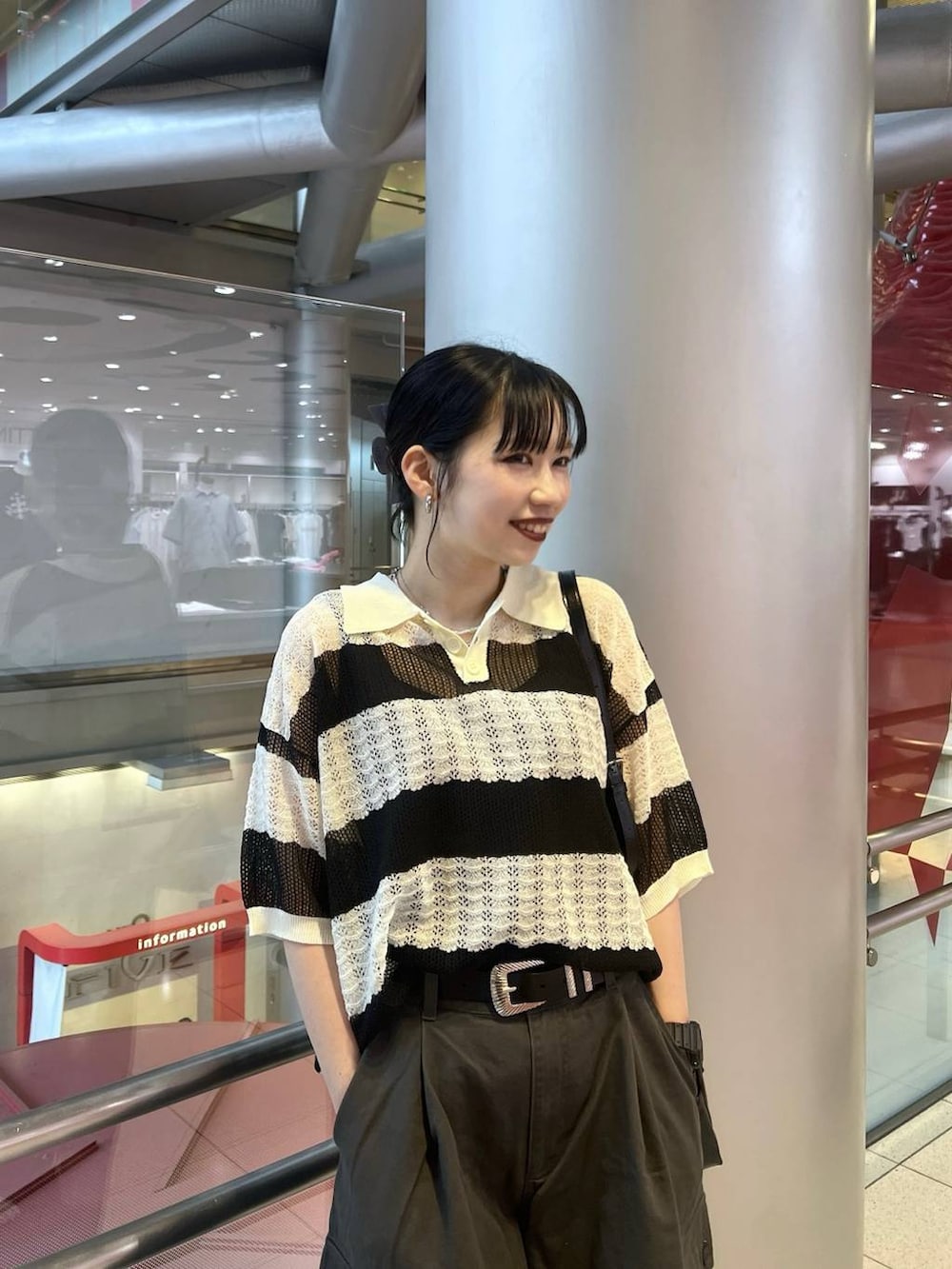 ブラック系のスニーカー、ブラック系のショルダーバッグ、グレー系のカーゴパンツを着用したレディースの春コーディネートの2枚目の写真