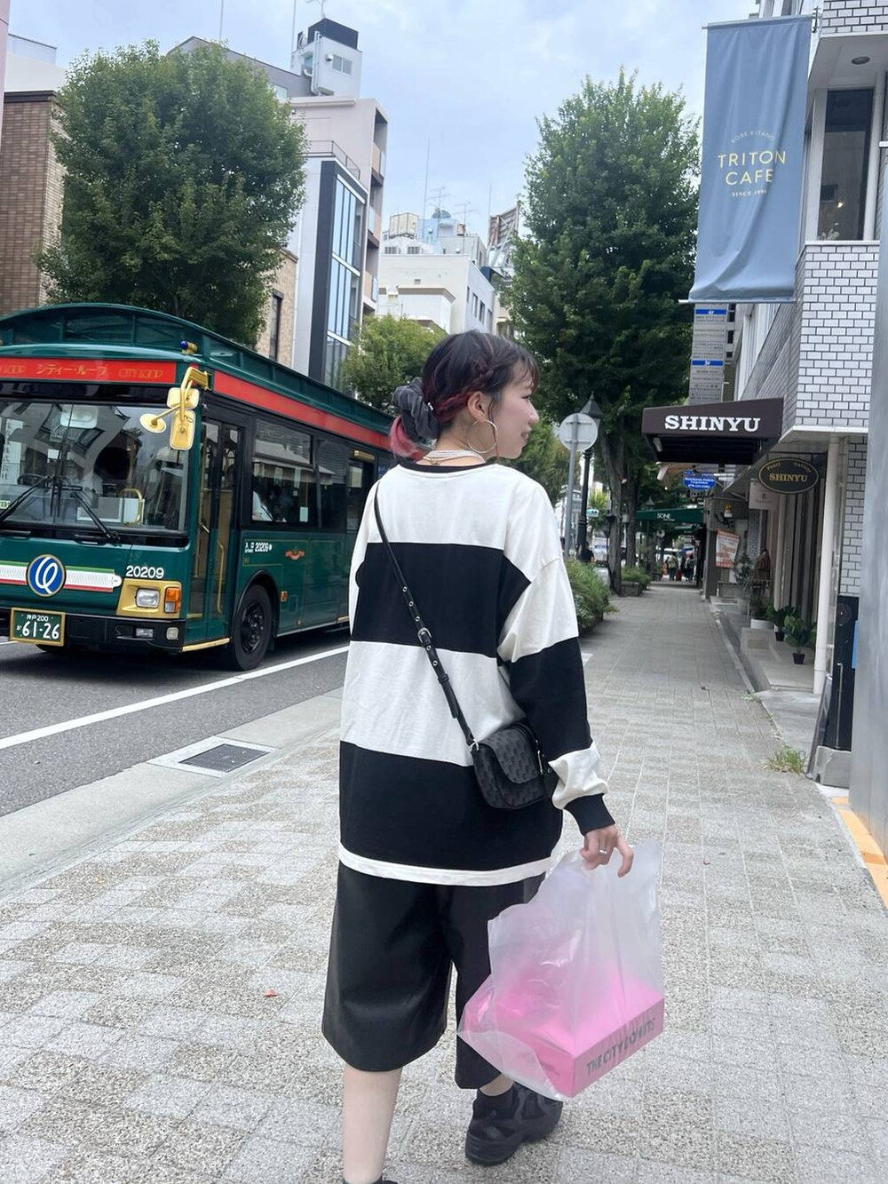 ブラック系のショルダーバッグ、ブラック系のその他パンツ、ホワイト系のTシャツ/カットソーを着用したレディースの秋コーディネートの2枚目の写真