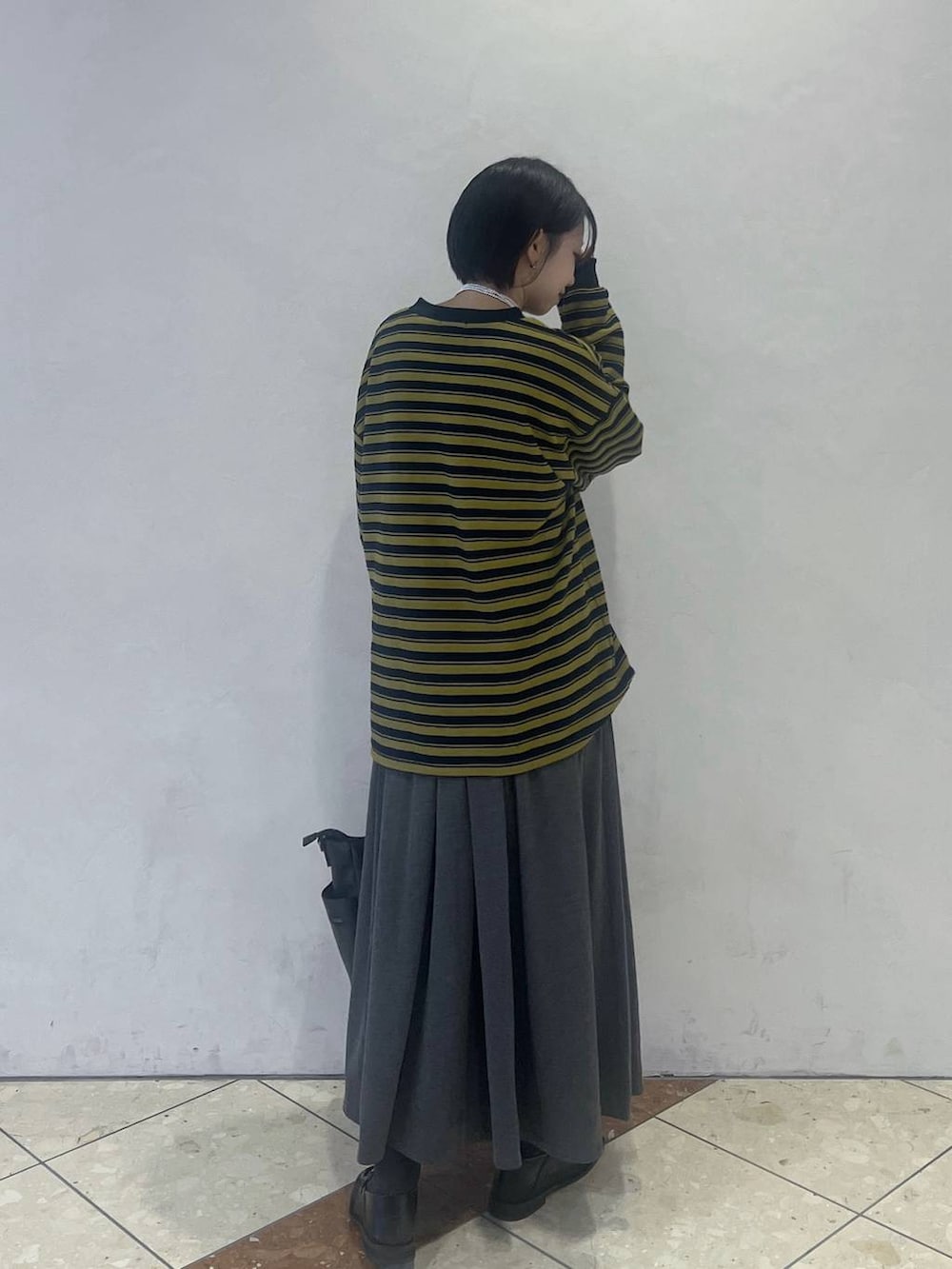 ブルー系のTシャツ/カットソー、ブラック系のボストンバッグ、グレー系のスカートを着用したレディースの秋コーディネートの2枚目の写真