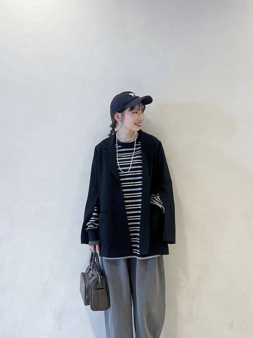 ブラック系のスニーカー、ブルー系のTシャツ/カットソー、ブラック系のテーラードジャケットを着用したレディースの冬コーディネートの2枚目の写真