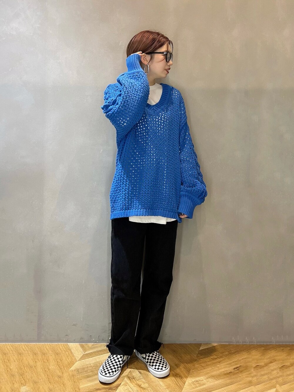 ブルー系のニット/セーター、ホワイト系のTシャツ/カットソー、ブラック系のデニムパンツを着用したレディースの冬コーディネートの2枚目の写真