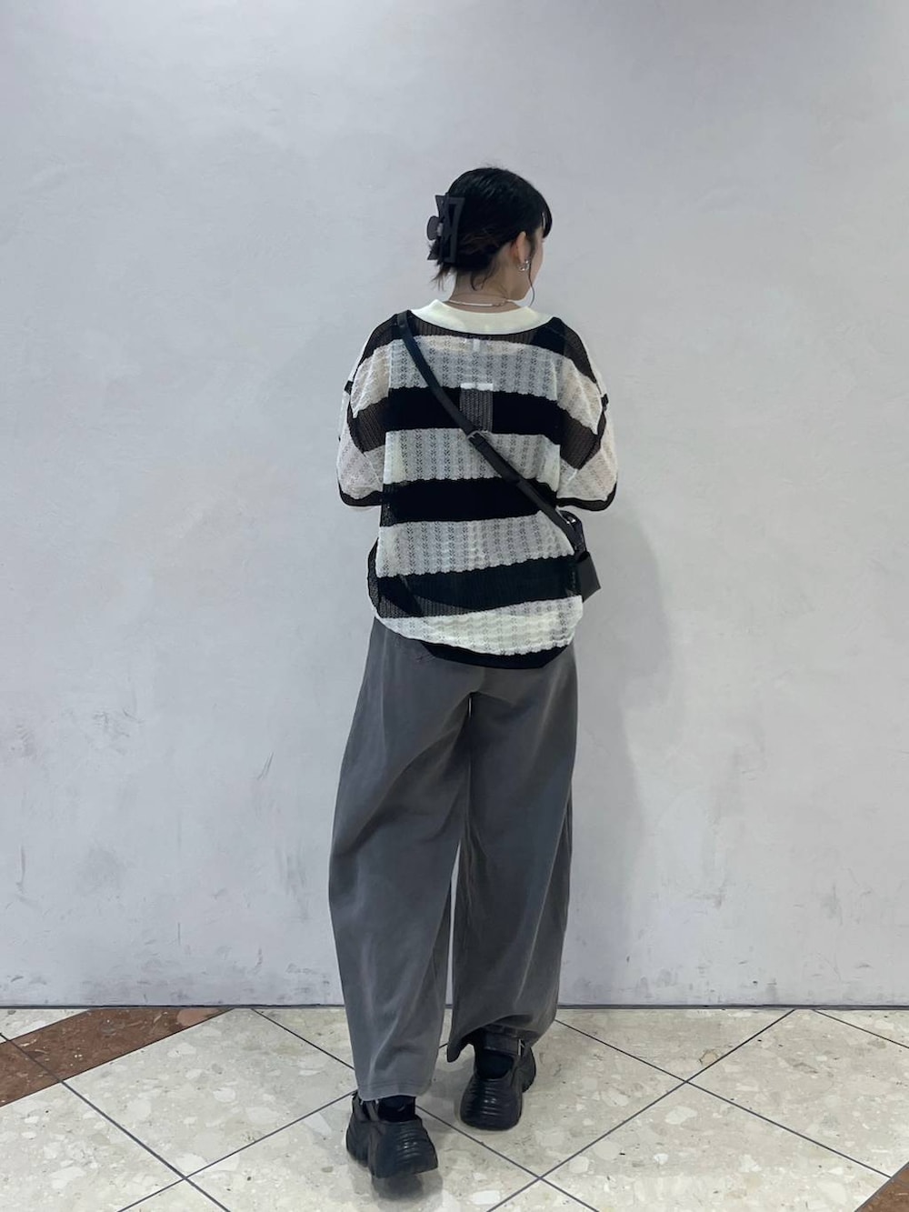 グレー系のスウェットパンツ、ブラック系のショルダーバッグ、ブラック系のサンダルを着用したレディースの夏コーディネートの2枚目の写真