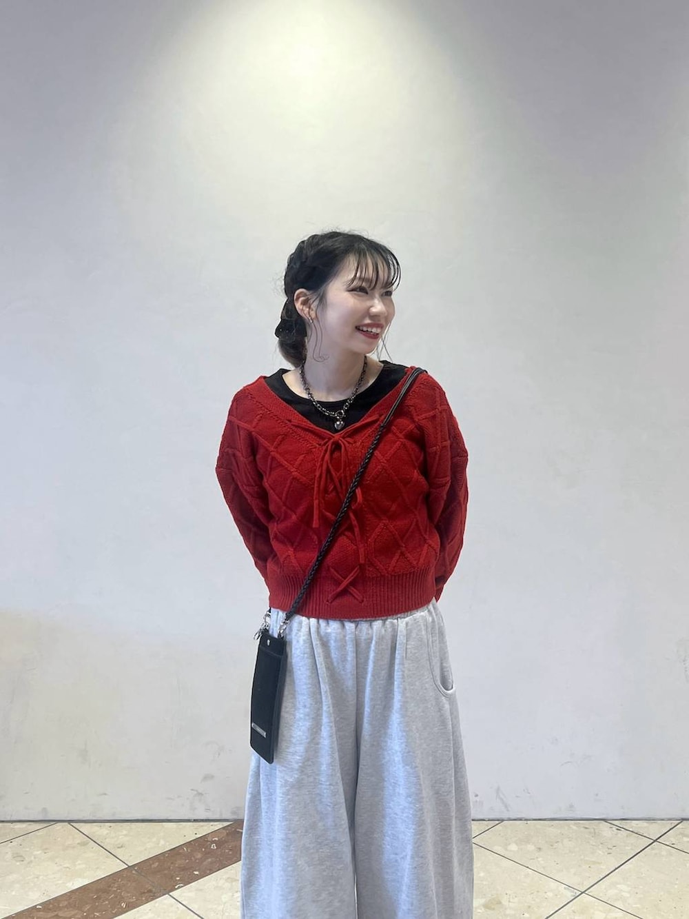 ブラック系のブーツ、グレー系のスウェットパンツ、レッド系のニット/セーターを着用したレディースの冬コーディネートの2枚目の写真