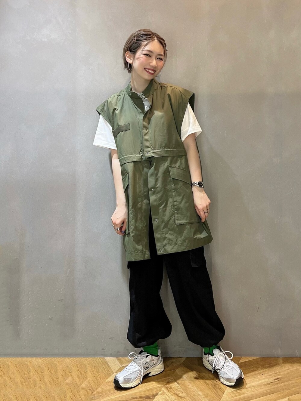 ホワイト系のTシャツ/カットソー、ブラック系のカーゴパンツ、グリーン系のジャケット/アウターを着用したレディースの春コーディネートの2枚目の写真