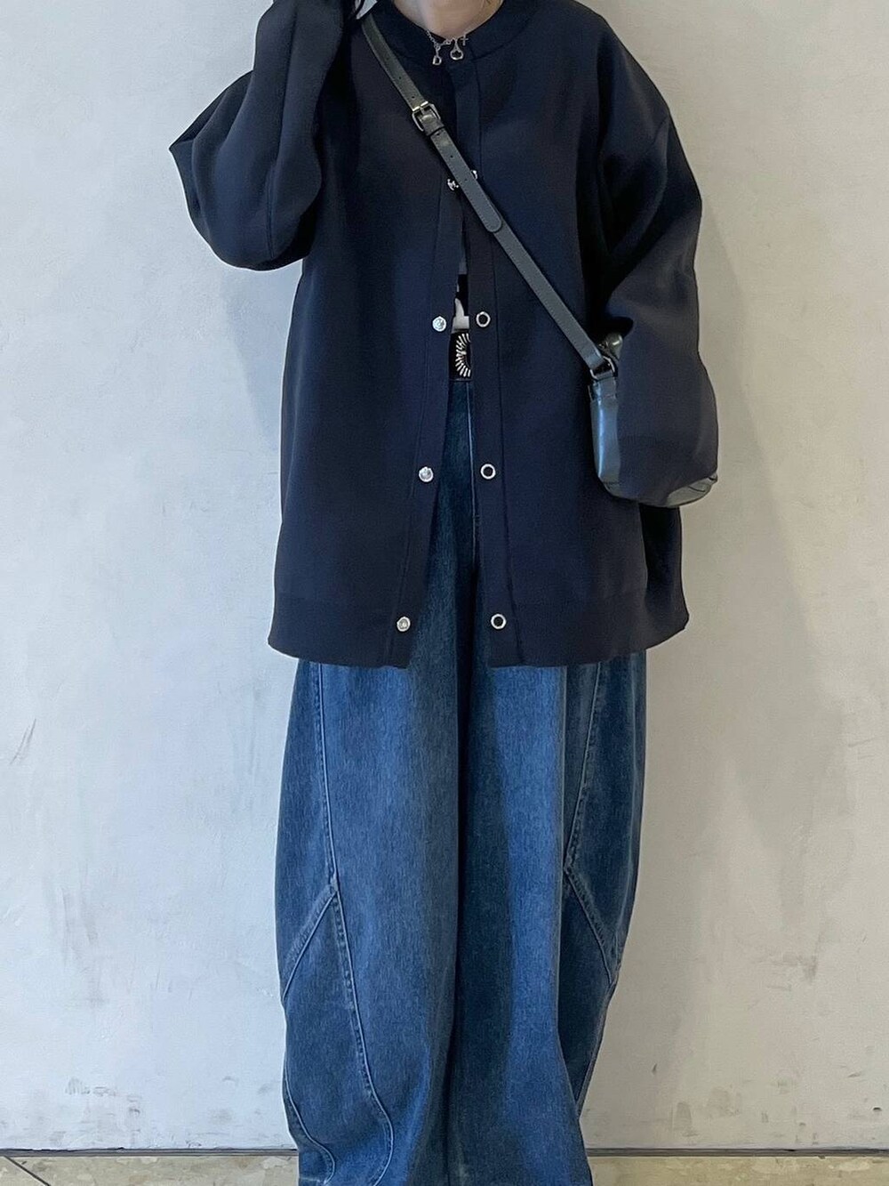 ブルー系のデニムパンツ、グレー系のショルダーバッグ、グレー系のカーディガン/ボレロを着用したレディースの春コーディネートの3枚目の写真