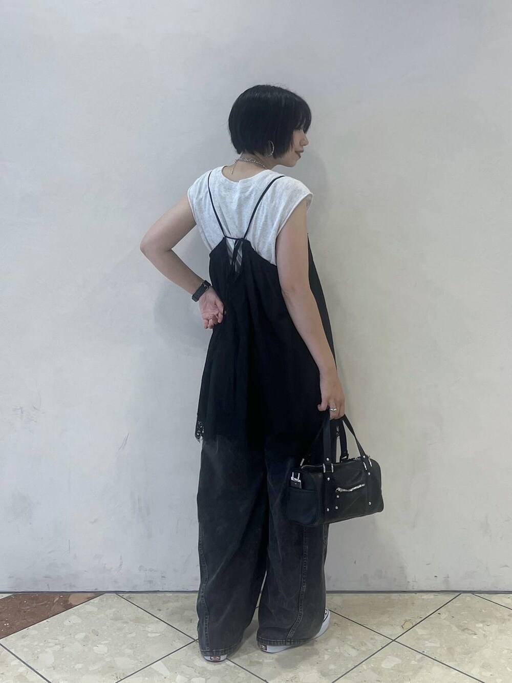 ブラック系のショルダーバッグ、グレー系のTシャツ/カットソー、ブラック系のデニムパンツを着用したレディースの夏コーディネートの2枚目の写真