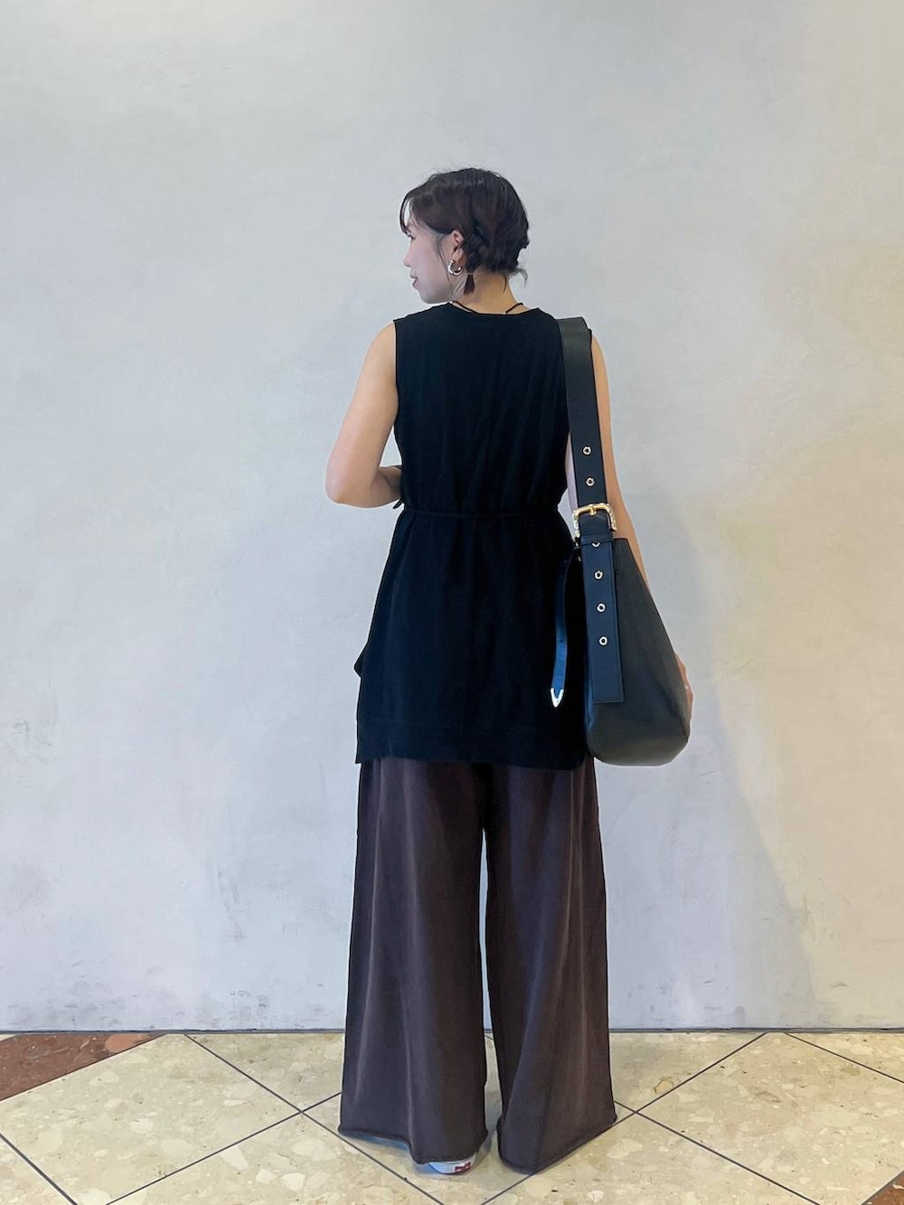 ブラック系のショルダーバッグ、ブラック系のTシャツ/カットソー、ブラウン系のスウェットパンツを着用したレディースの夏コーディネートの3枚目の写真