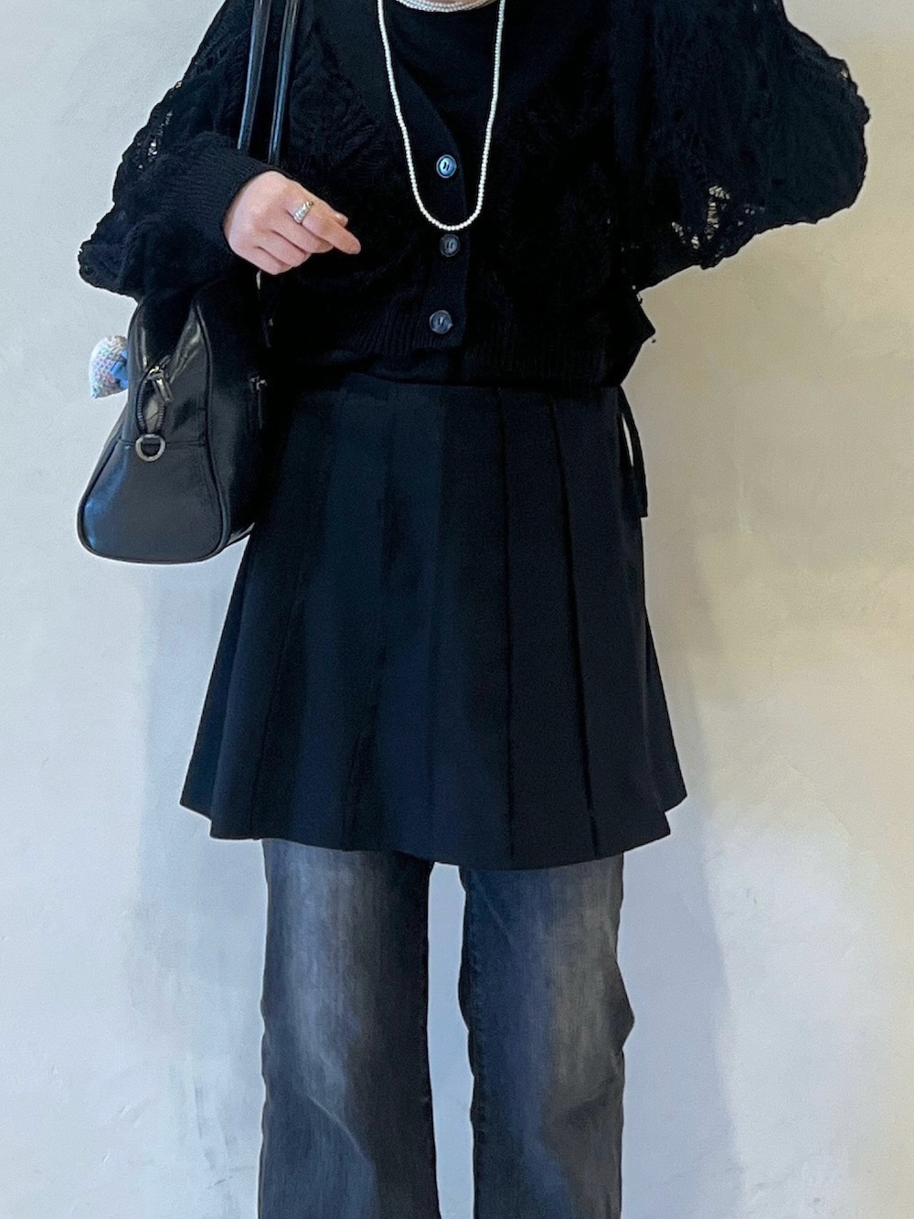 グレー系のデニムパンツ、ブラック系のその他シューズ、ブラック系のスカートを着用したレディースの春コーディネートの4枚目の写真