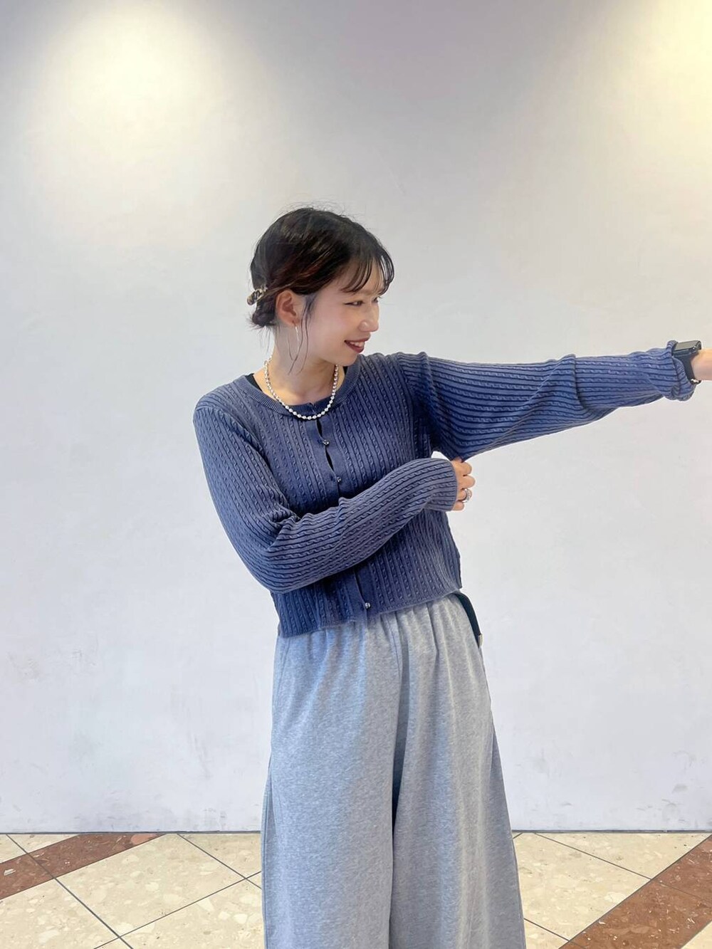 ブラック系のスニーカー、グレー系のスウェットパンツ、ブルー系のカーディガン/ボレロを着用したレディースの秋コーディネートの2枚目の写真