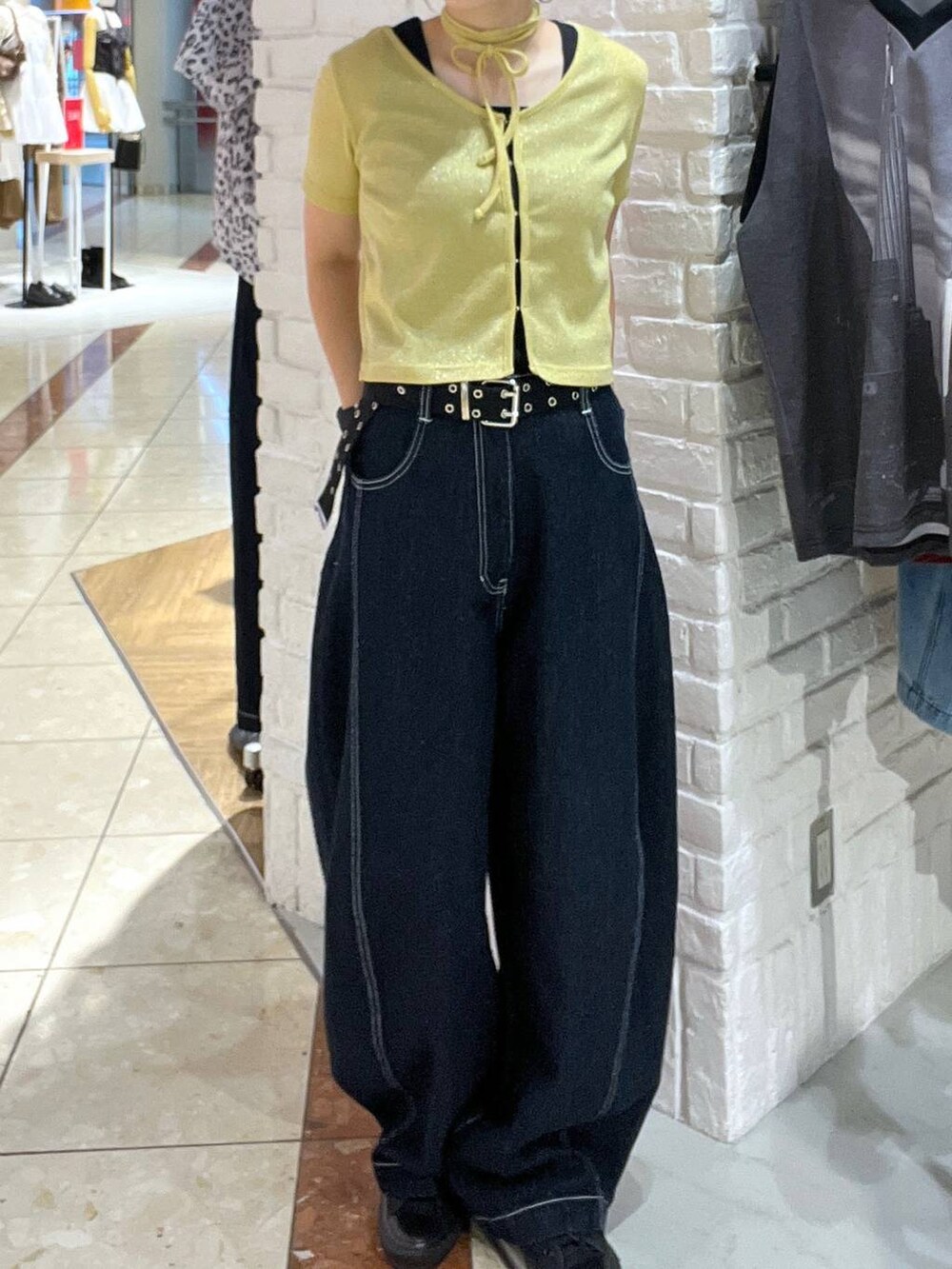 イエロー系のTシャツ/カットソー、ブルー系のデニムパンツ、ブラック系のキャップを着用したレディースの夏コーディネートの2枚目の写真