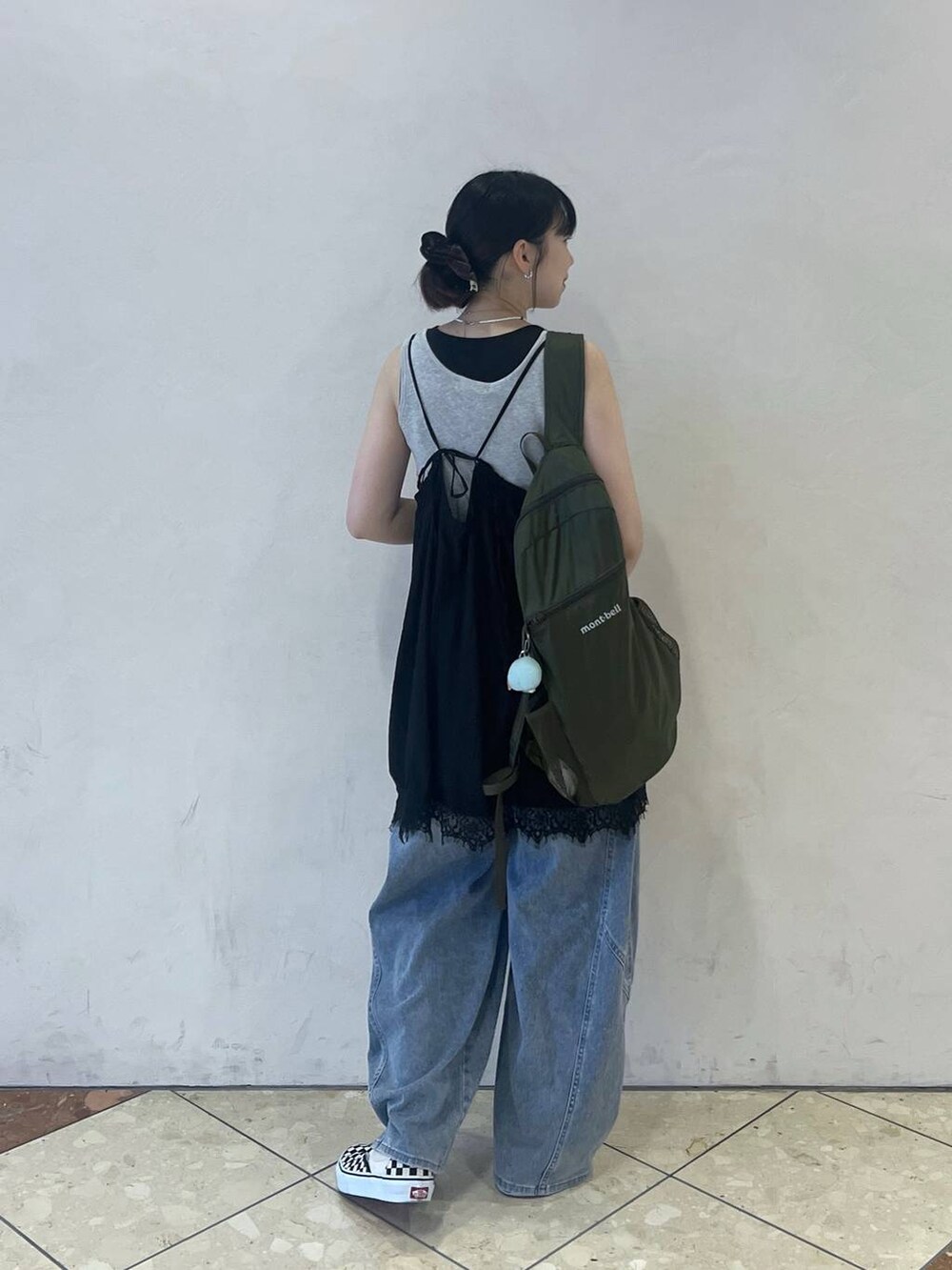 ブルー系のデニムパンツ、グレー系のタンクトップ、ブラック系のワンピースを着用したレディースの夏コーディネートの2枚目の写真