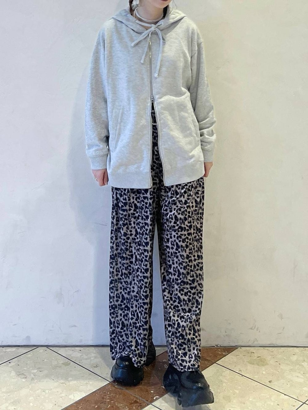 ブラック系のブーツ、グレー系のパーカー、ベージュ系のその他パンツを着用したレディースの冬コーディネートの2枚目の写真