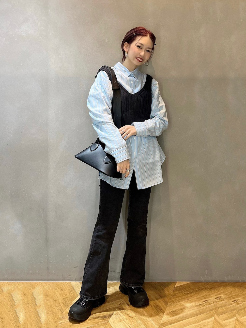 ブルー系のシャツ/ブラウス、ブラック系のボストンバッグ、ベージュ系のトレンチコートを着用したレディースの冬コーディネートの2枚目の写真