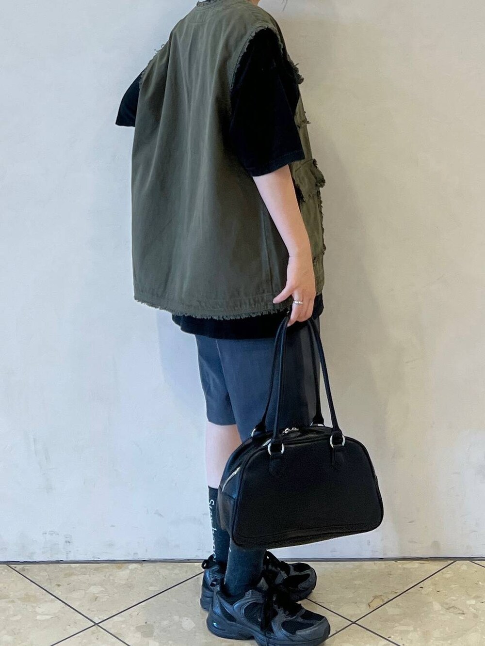 グレー系のスラックス、グリーン系のその他アウター、ブラック系のTシャツ/カットソーを着用したレディースの夏コーディネートの3枚目の写真