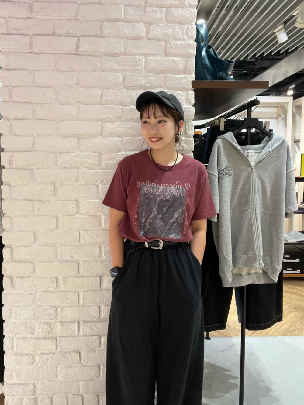 レッド系のTシャツ/カットソー、ブラック系のスウェットパンツ、ブラック系のベルトを着用したレディースの夏コーディネートの2枚目の写真