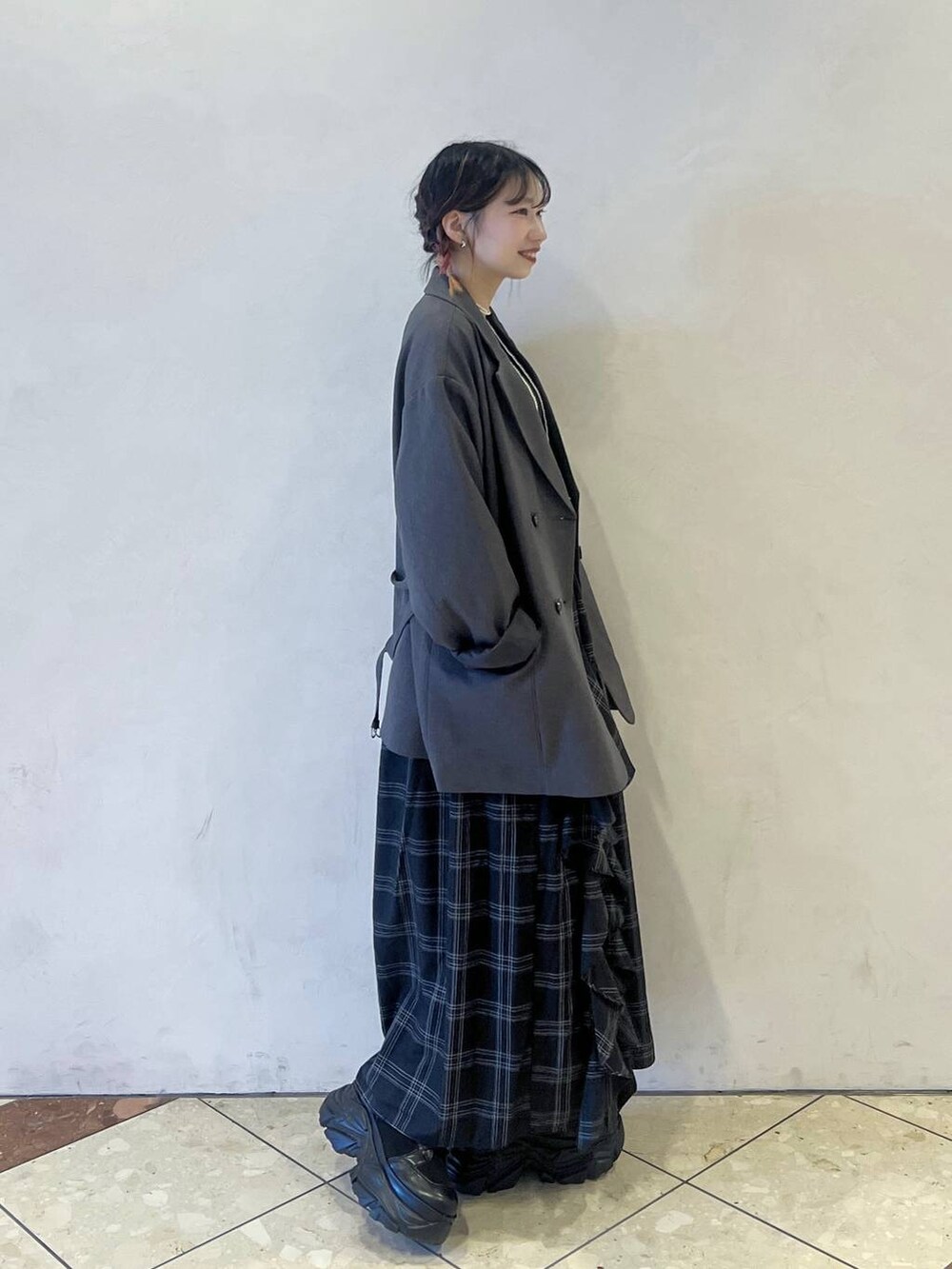 ブラック系のブーツ、グレー系のテーラードジャケット、ブラック系のスカートを着用したレディースの秋コーディネートの2枚目の写真