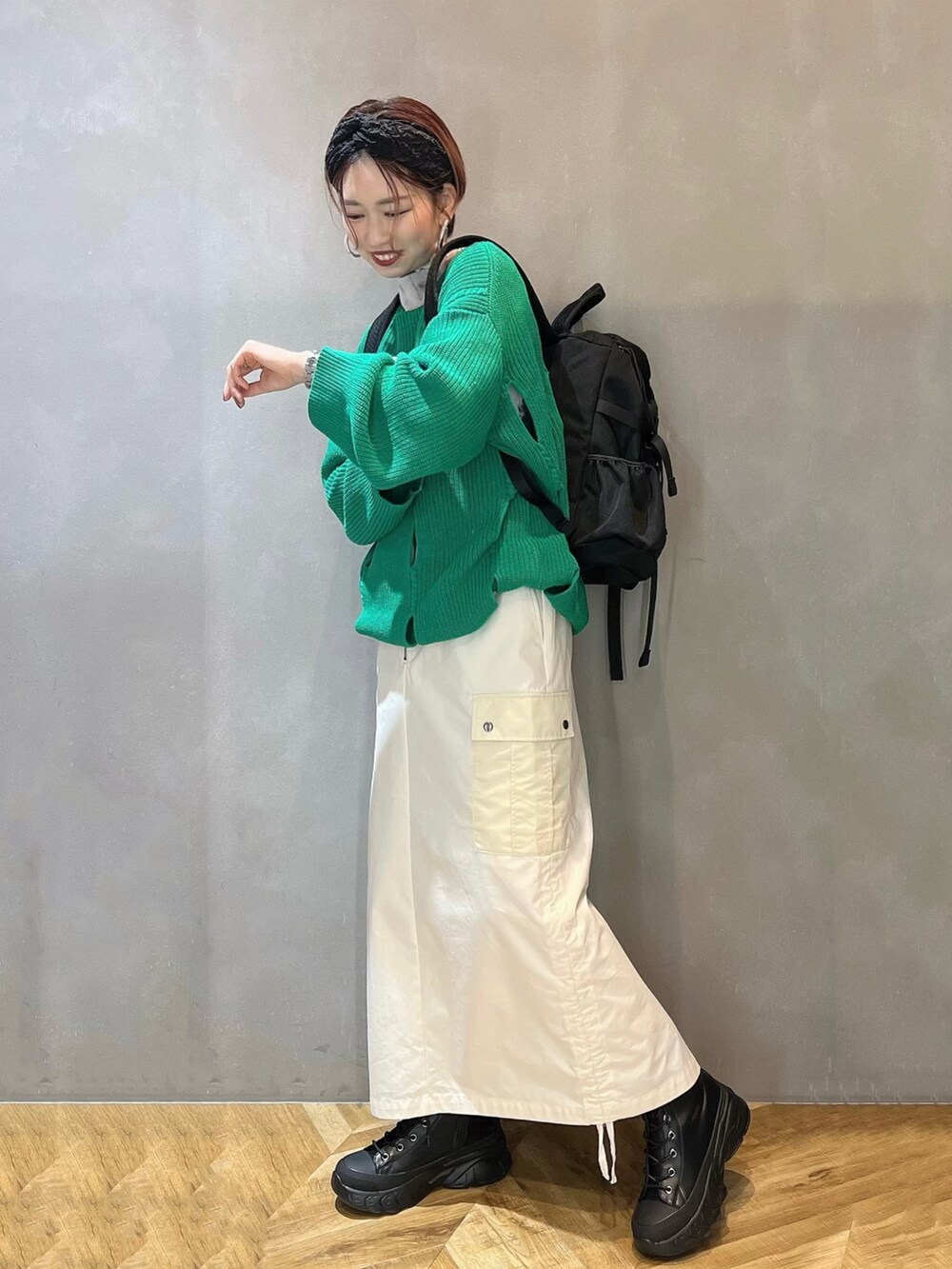 ブラック系のブーツ、ホワイト系のスカート、グリーン系のニット/セーターを着用したレディースの冬コーディネートの4枚目の写真