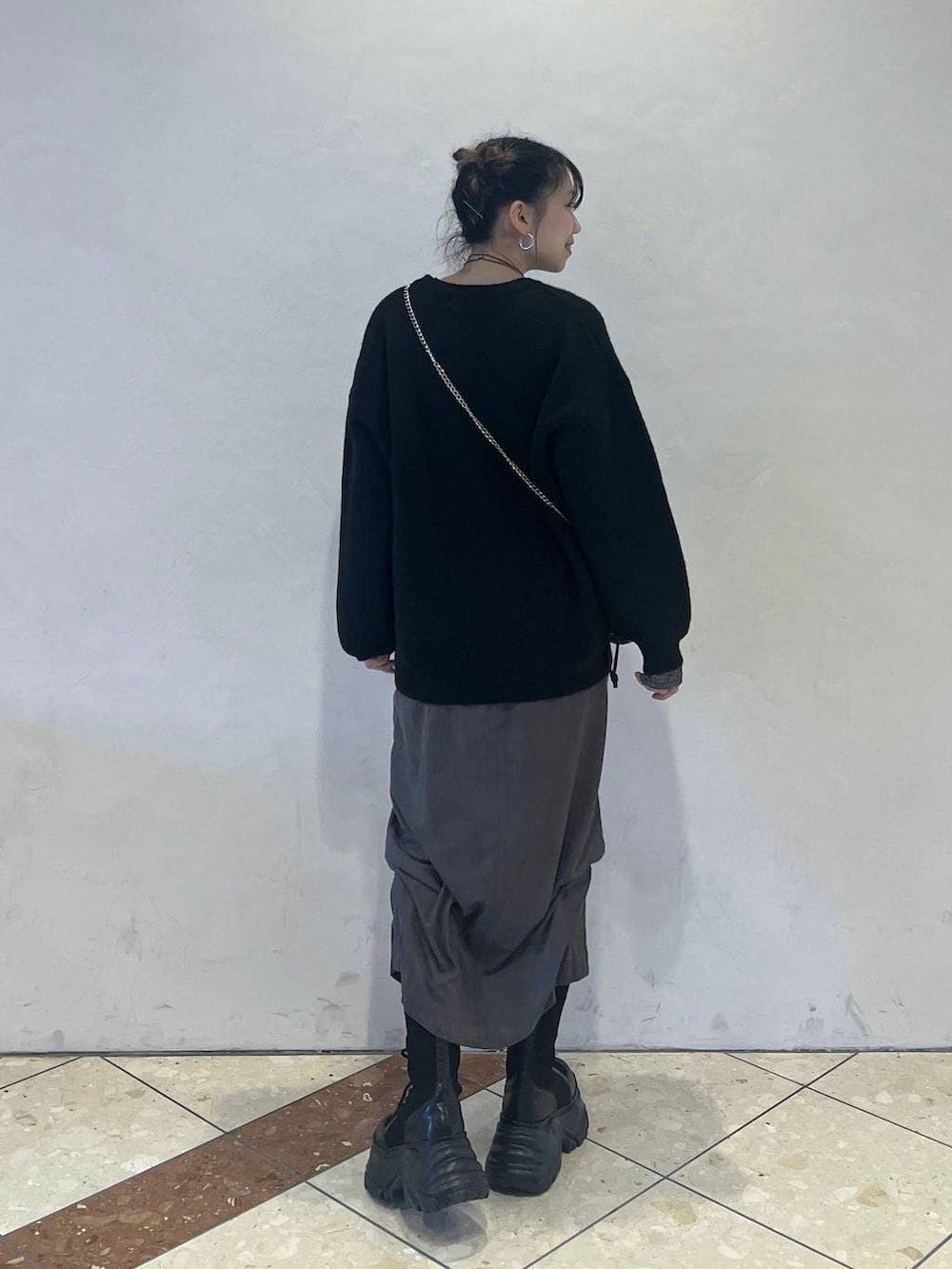 ブラック系のブーツ、その他のハンドバッグ、グレー系のスカートを着用したレディースの冬コーディネートの3枚目の写真