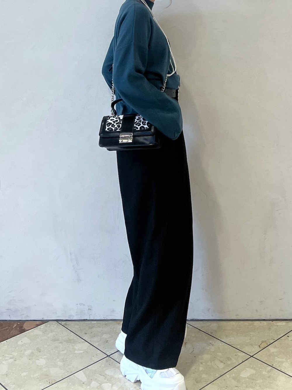 ホワイト系のスニーカー、グリーン系のニット/セーター、その他のハンドバッグを着用したレディースの秋コーディネートの2枚目の写真