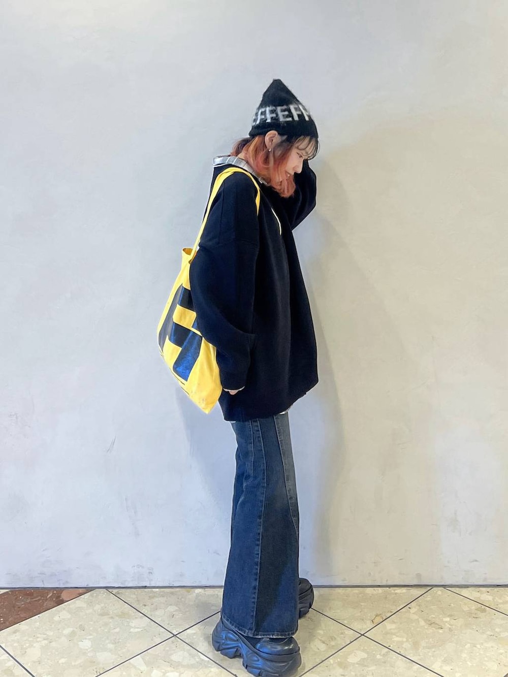 ブラック系のブーツ、ブラック系のニット/セーター、ブルー系のデニムパンツを着用したレディースの秋コーディネートの2枚目の写真