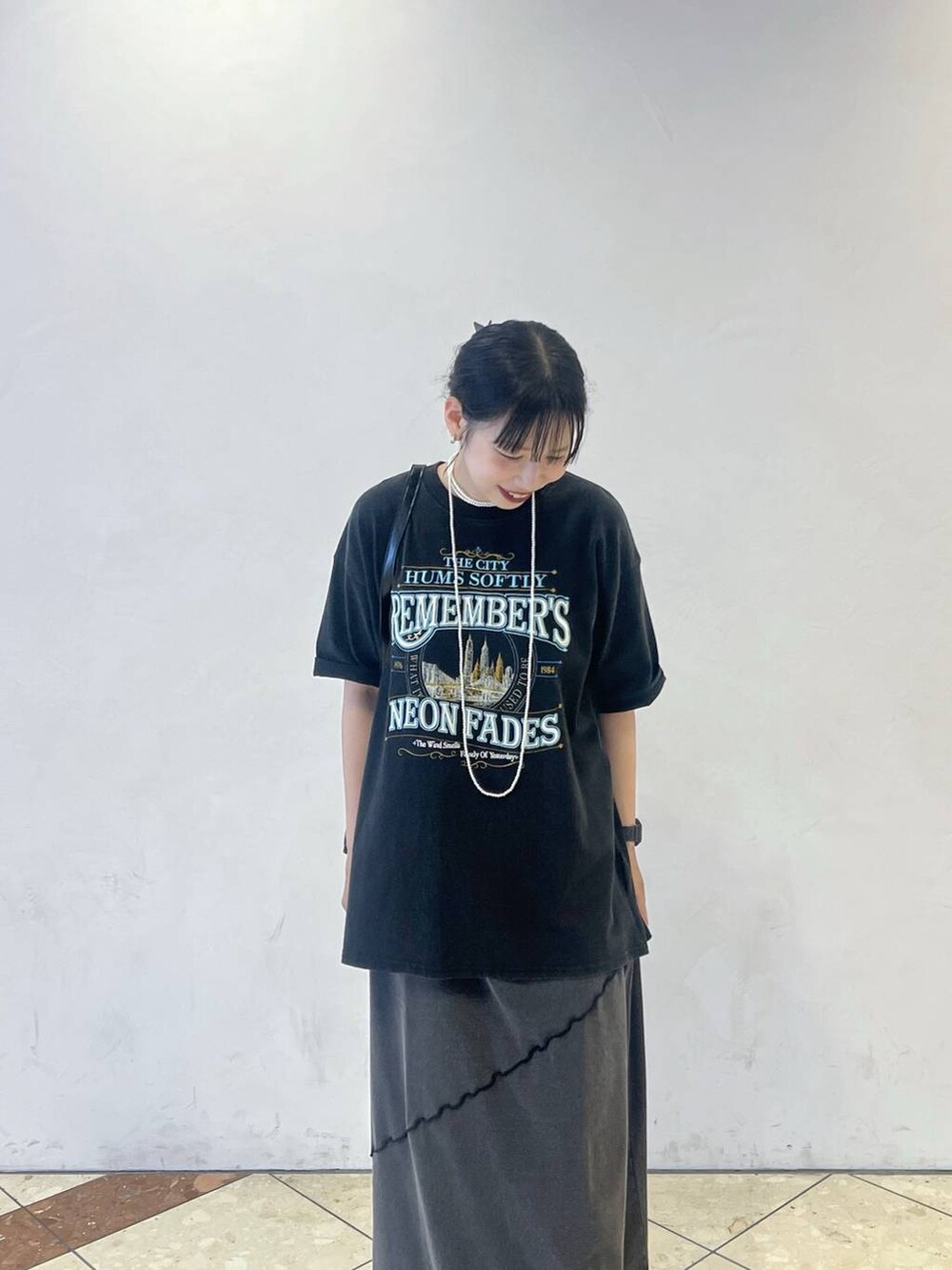 ブラック系のワンピース、ブラック系のショルダーバッグ、グレー系のTシャツ/カットソーを着用したレディースの夏コーディネートの2枚目の写真