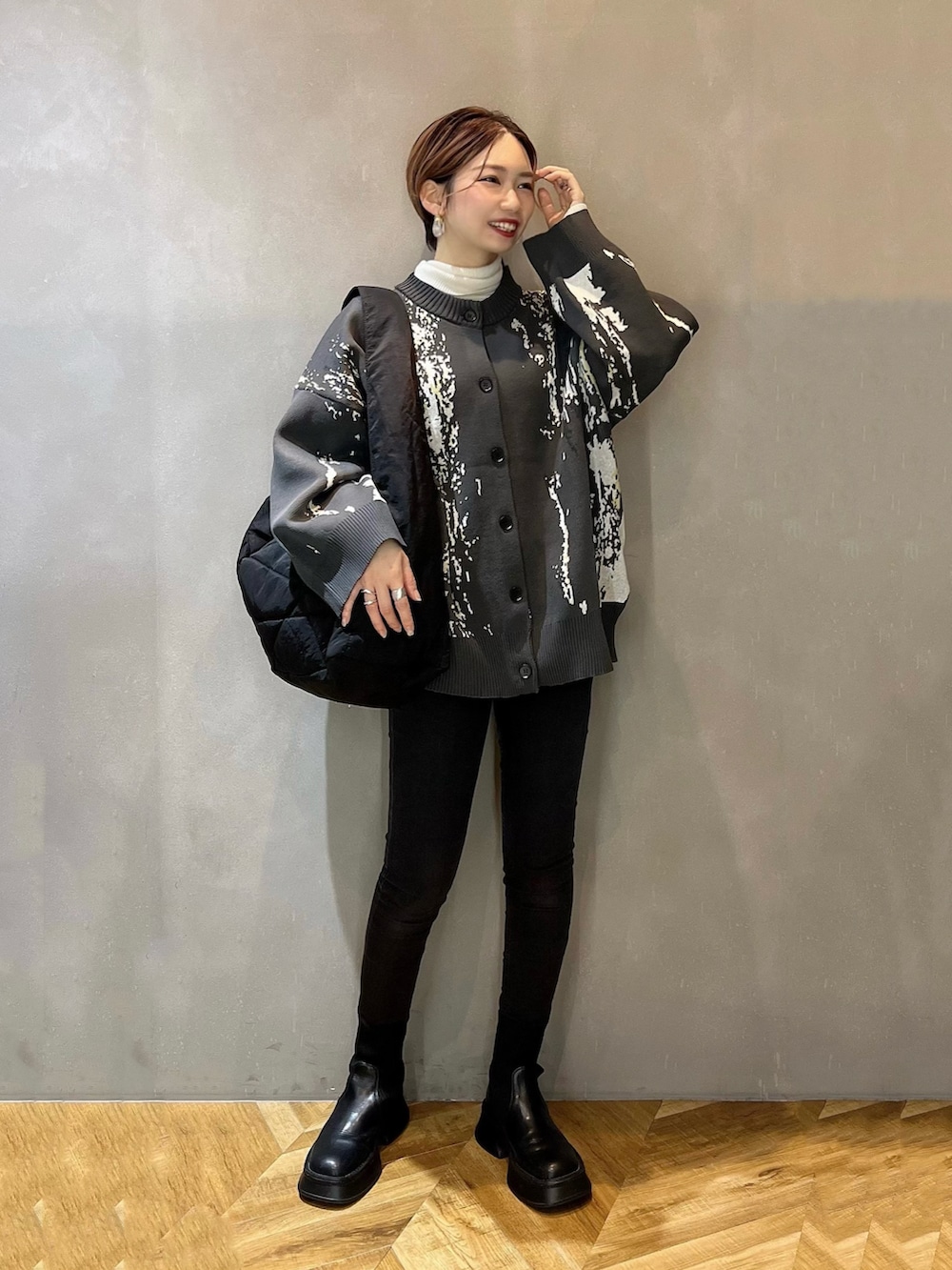 グレー系のカーディガン/ボレロ、ホワイト系のニット/セーター、ブラック系のボディバッグ/ウエストポーチを着用したレディースの冬コーディネートの2枚目の写真