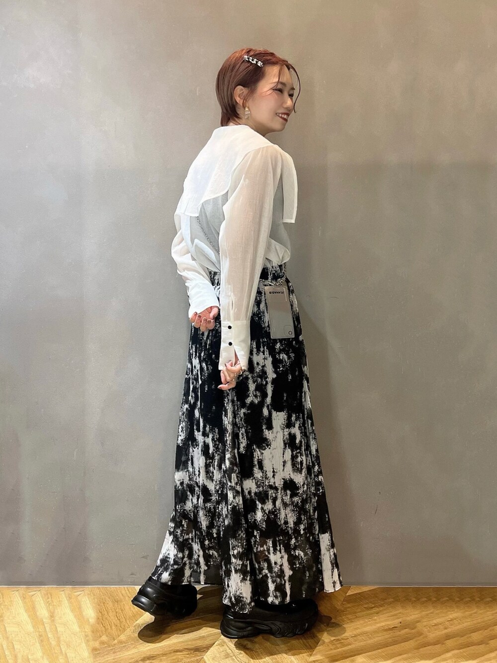 ブラック系のブーツ、ブラック系のスカート、ホワイト系のシャツ/ブラウスを着用したレディースの春コーディネートの2枚目の写真