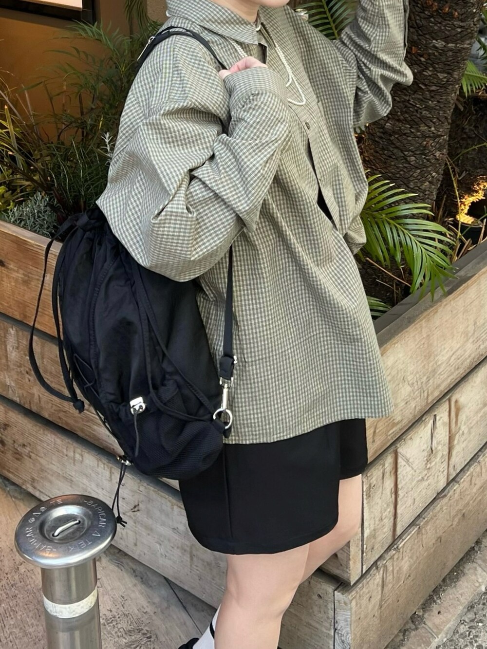 ブラック系のショルダーバッグ、ブラック系のその他パンツ、グリーン系のシャツ/ブラウスを着用したレディースの春コーディネートの3枚目の写真