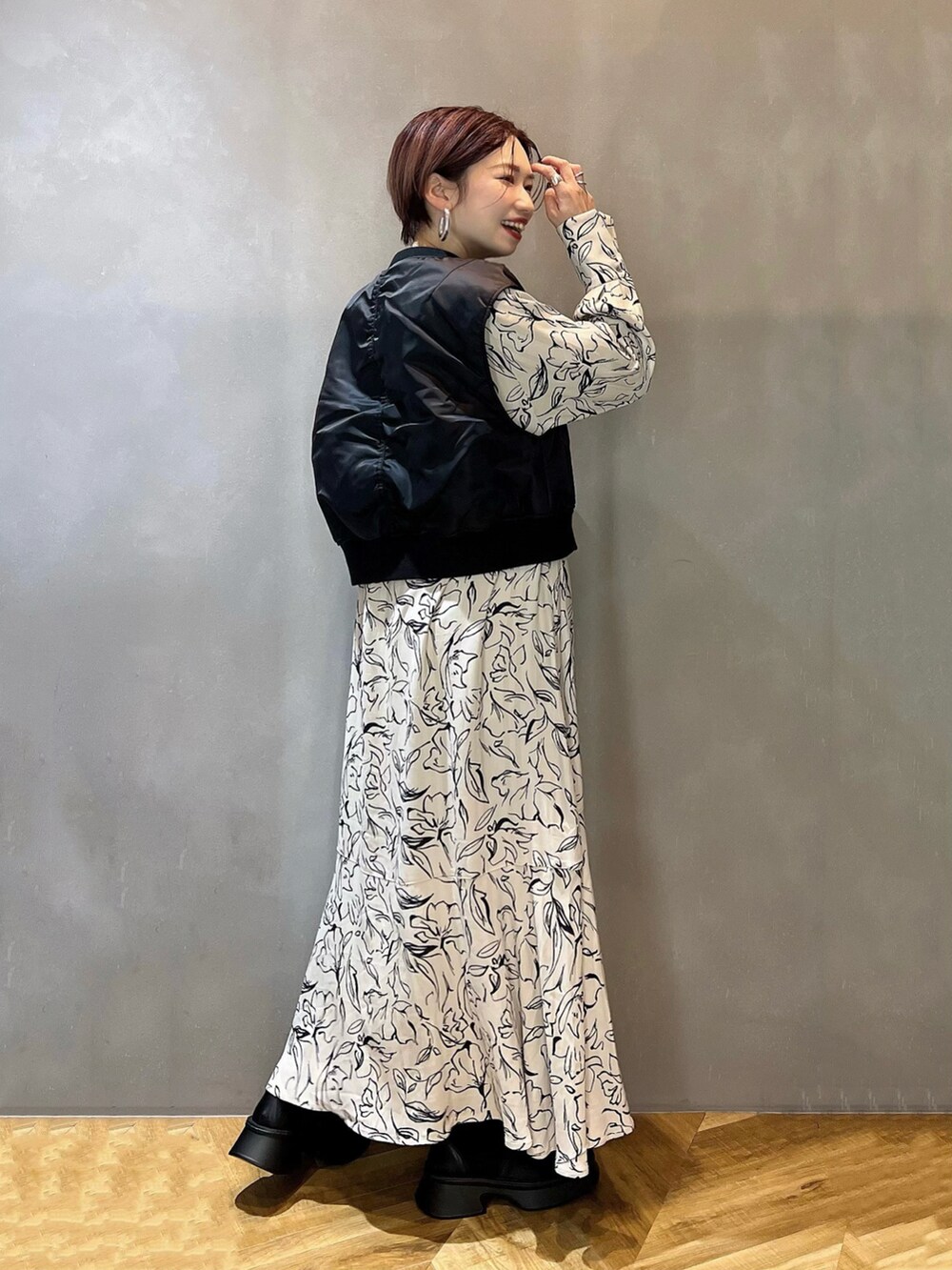 ブラック系のブーツ、ホワイト系のシャツワンピース、ブラック系のMA-1を着用したレディースの冬コーディネートの2枚目の写真