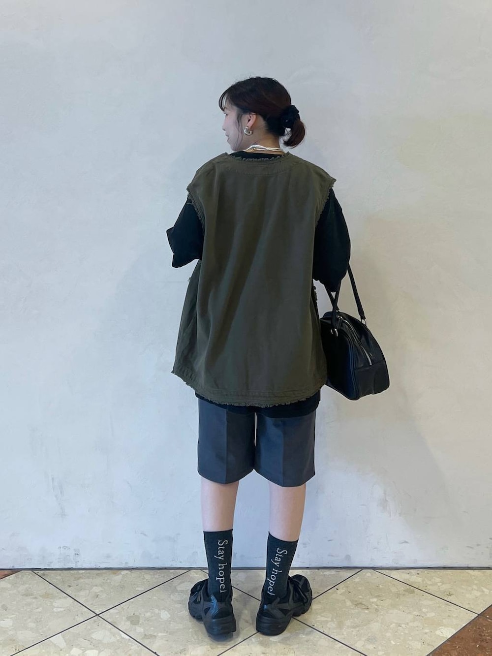 グレー系のスラックス、グリーン系のその他アウター、ブラック系のTシャツ/カットソーを着用したレディースの夏コーディネートの2枚目の写真