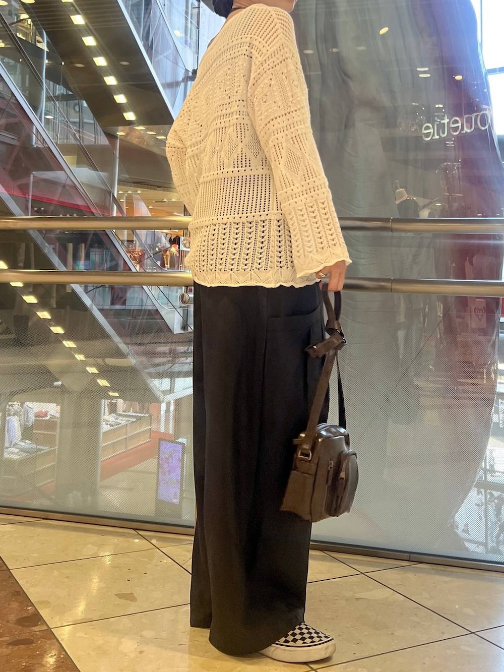 ブルー系のタンクトップ、ブラウン系のショルダーバッグ、ホワイト系のニット/セーターを着用したレディースの春コーディネートの4枚目の写真