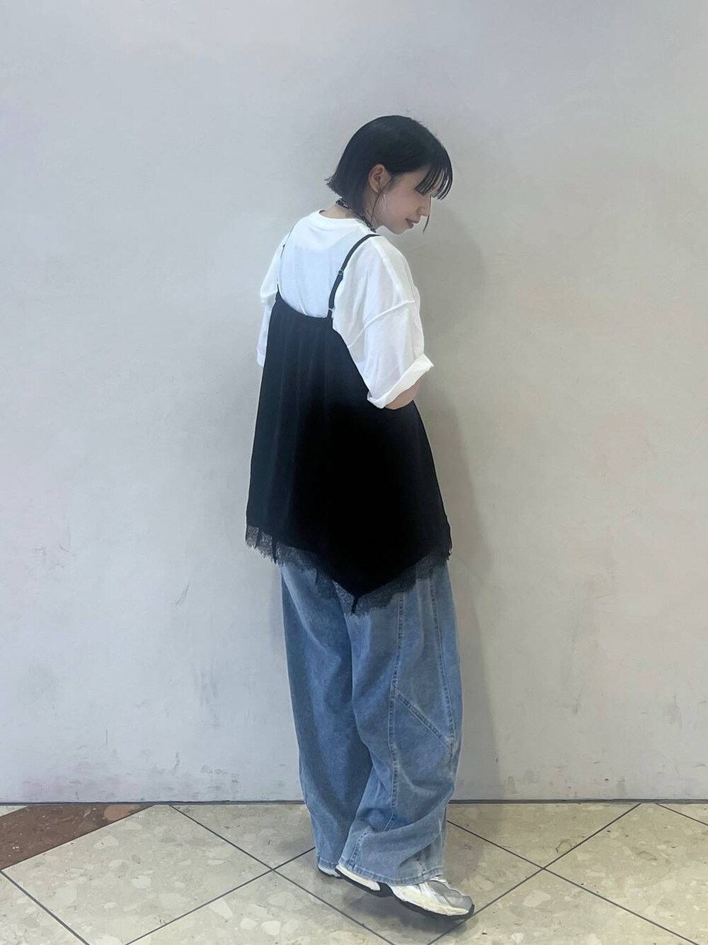ブルー系のデニムパンツ、ブラック系のキャミソール、ホワイト系のTシャツ/カットソーを着用したレディースの春コーディネートの2枚目の写真