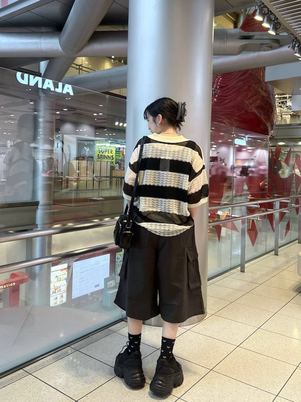 ブラック系のスニーカー、ブラック系のショルダーバッグ、グレー系のカーゴパンツを着用したレディースの春コーディネートの6枚目の写真