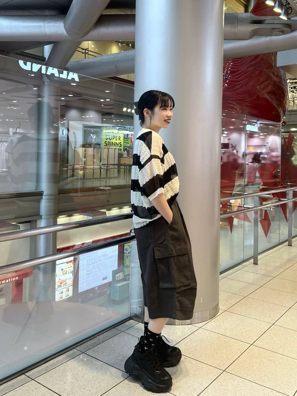 ブラック系のスニーカー、ブラック系のショルダーバッグ、グレー系のカーゴパンツを着用したレディースの春コーディネートの4枚目の写真