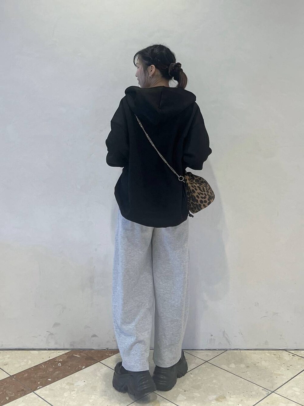 ブラック系のブーツ、グレー系のスウェットパンツ、ブラック系のパーカーを着用したレディースの冬コーディネートの3枚目の写真