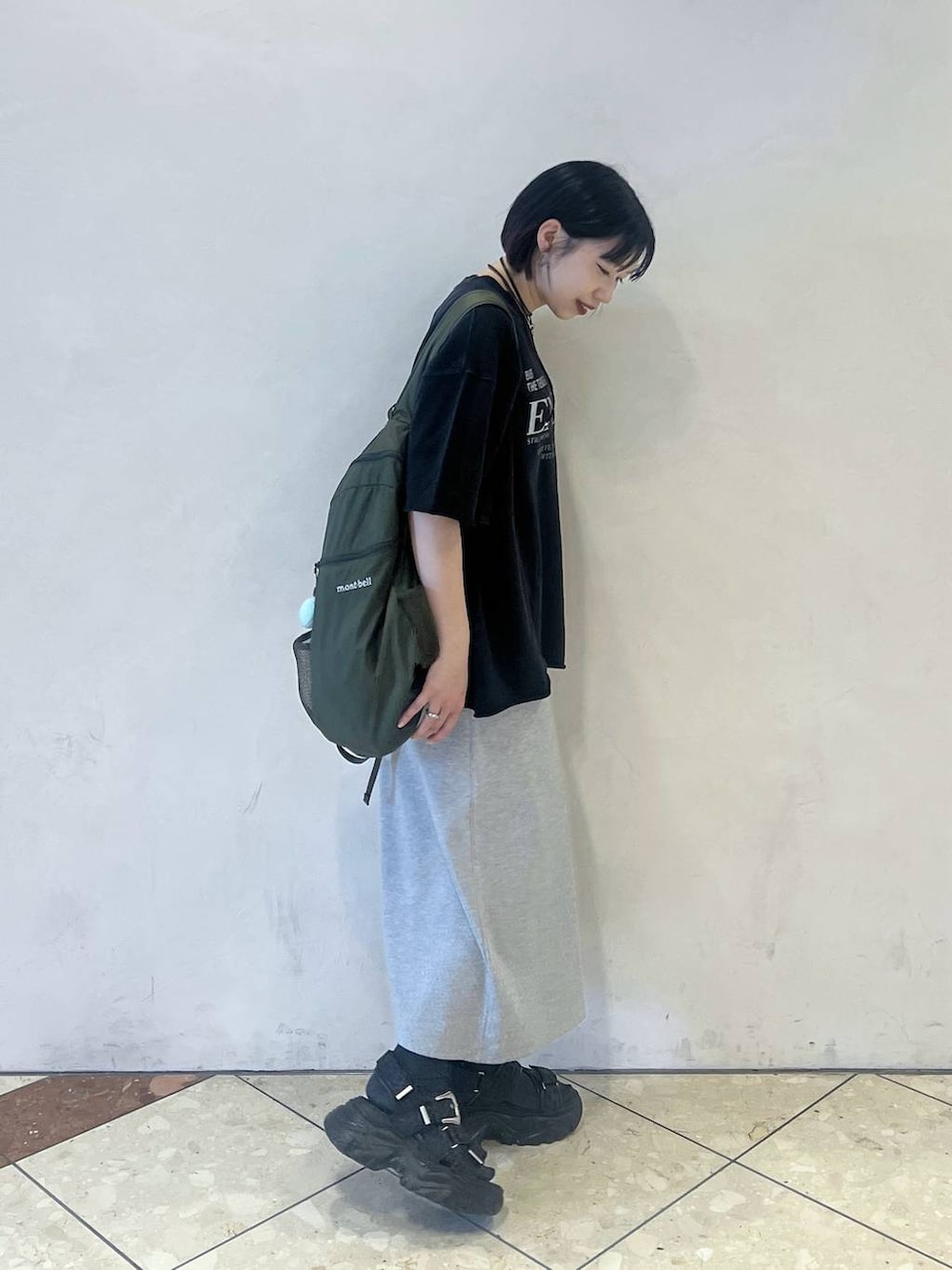 ブラック系のサンダル、ブラック系のTシャツ/カットソー、グレー系のワンピースを着用したレディースの春コーディネートの2枚目の写真