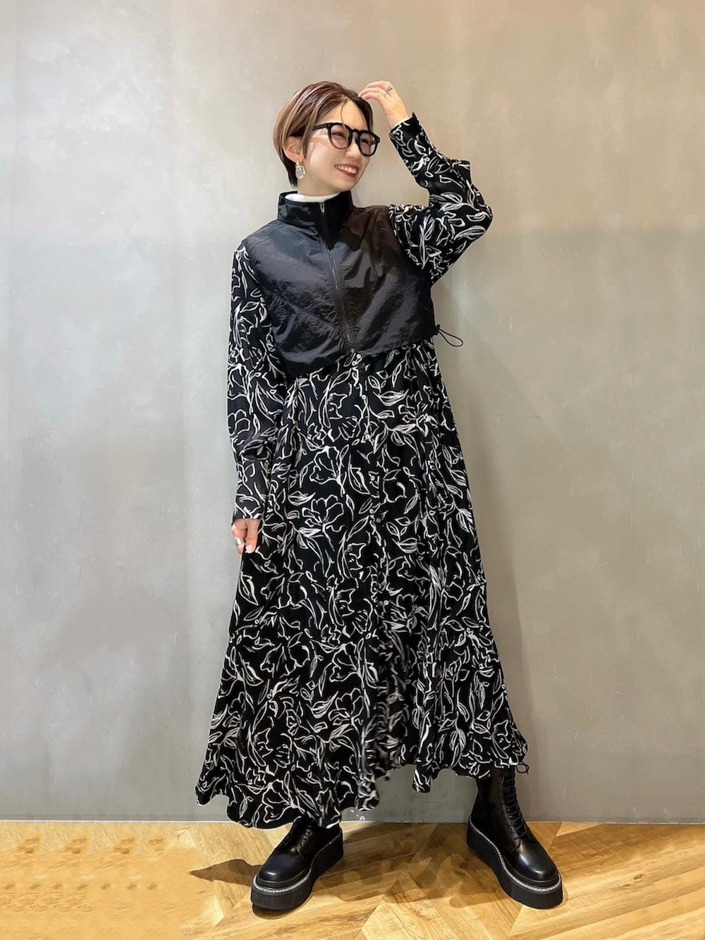 ホワイト系のニット/セーター、ブラック系のブーツ、ブラック系のシャツワンピースを着用したレディースの冬コーディネートの2枚目の写真