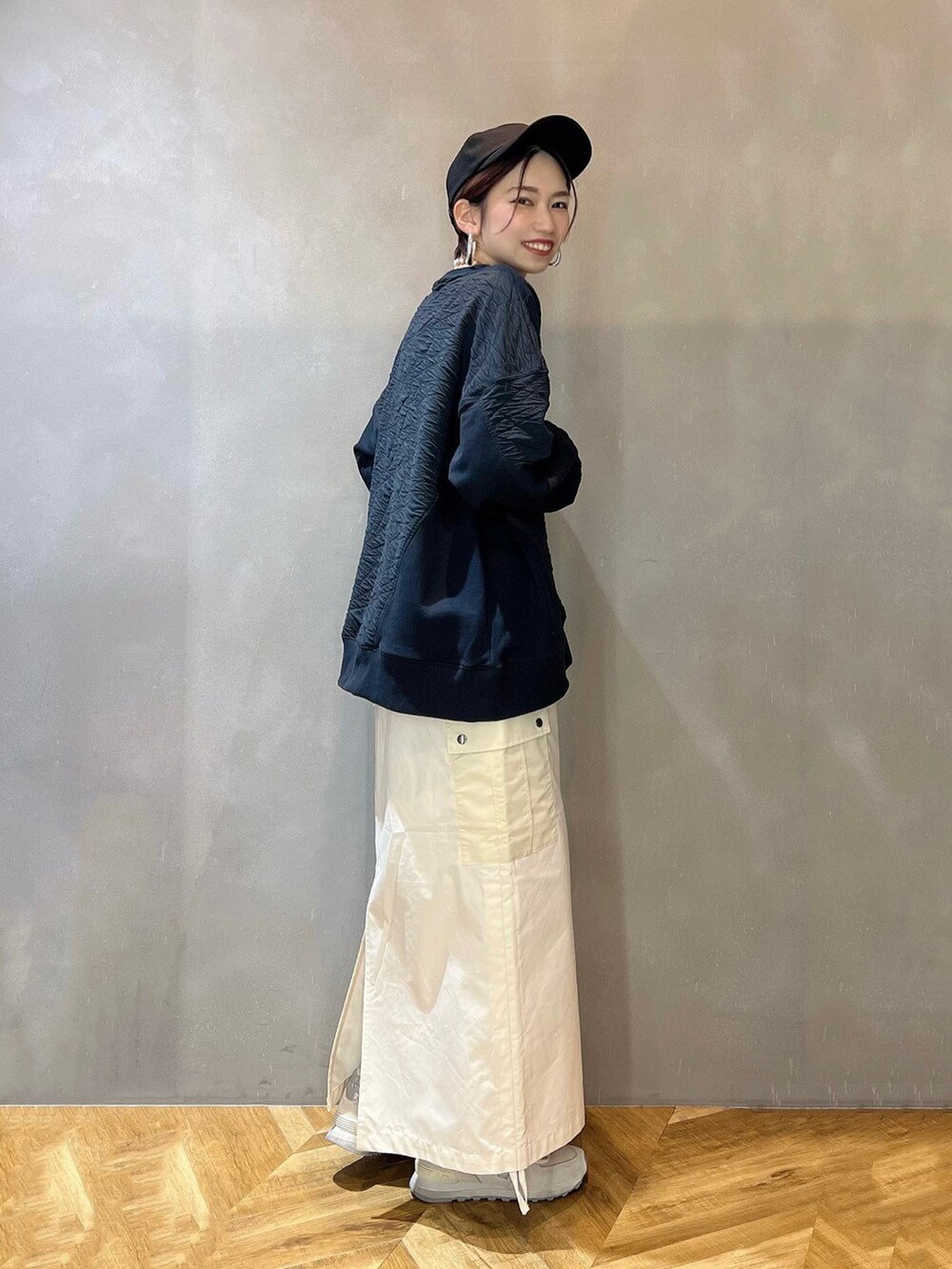 ホワイト系のスニーカー、ホワイト系のスカート、ブラック系のスウェットを着用したレディースの冬コーディネートの2枚目の写真