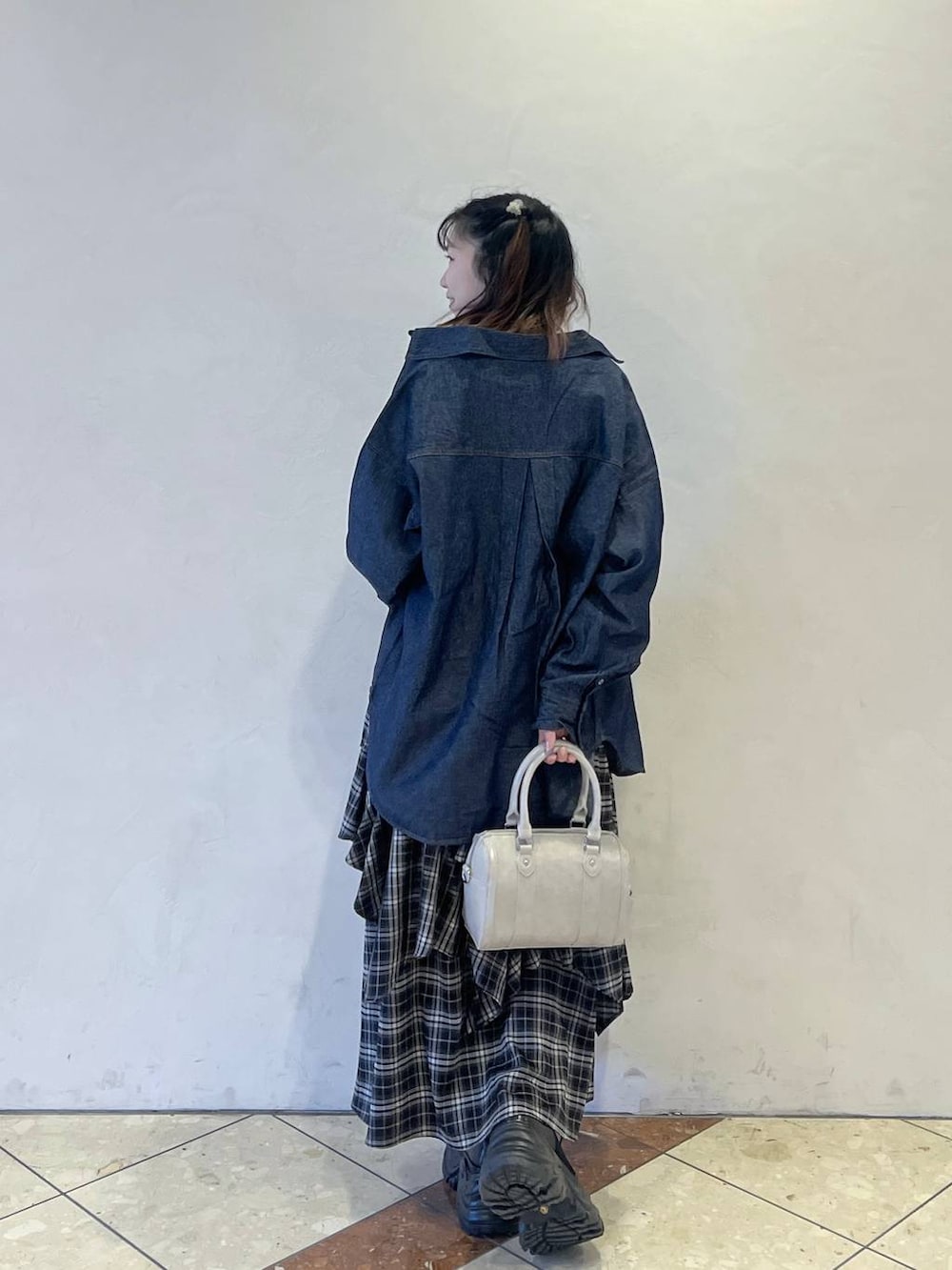 ブラック系のブーツ、ブラック系のスカート、ホワイト系のボストンバッグを着用したレディースの冬コーディネートの3枚目の写真