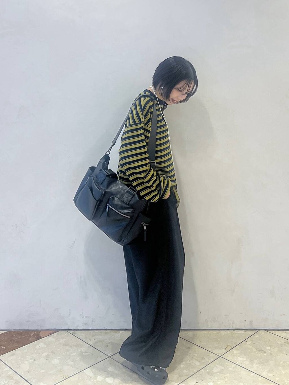 ブルー系のTシャツ/カットソー、ブラック系のスラックス、ブラック系のボストンバッグを着用したレディースの秋コーディネートの2枚目の写真