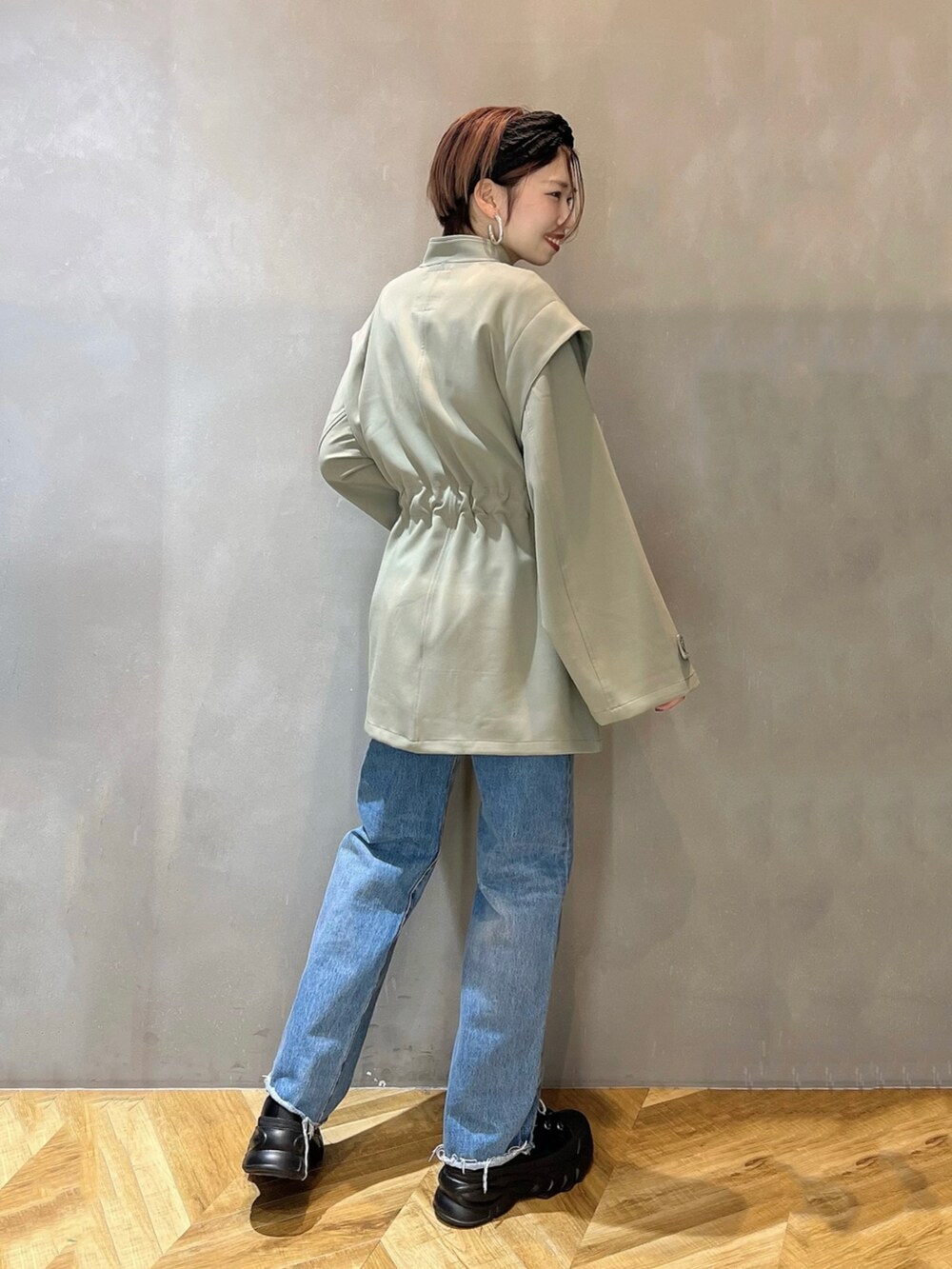 ブルー系のデニムパンツ、ブラック系のショルダーバッグ、ブラック系のブーツを着用したレディースの冬コーディネートの4枚目の写真